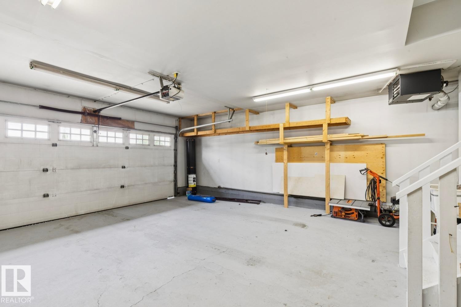 Two-car garage featuring a sectional overhead door with window inserts - 16765 119 Street Nw, Edmonton, AB