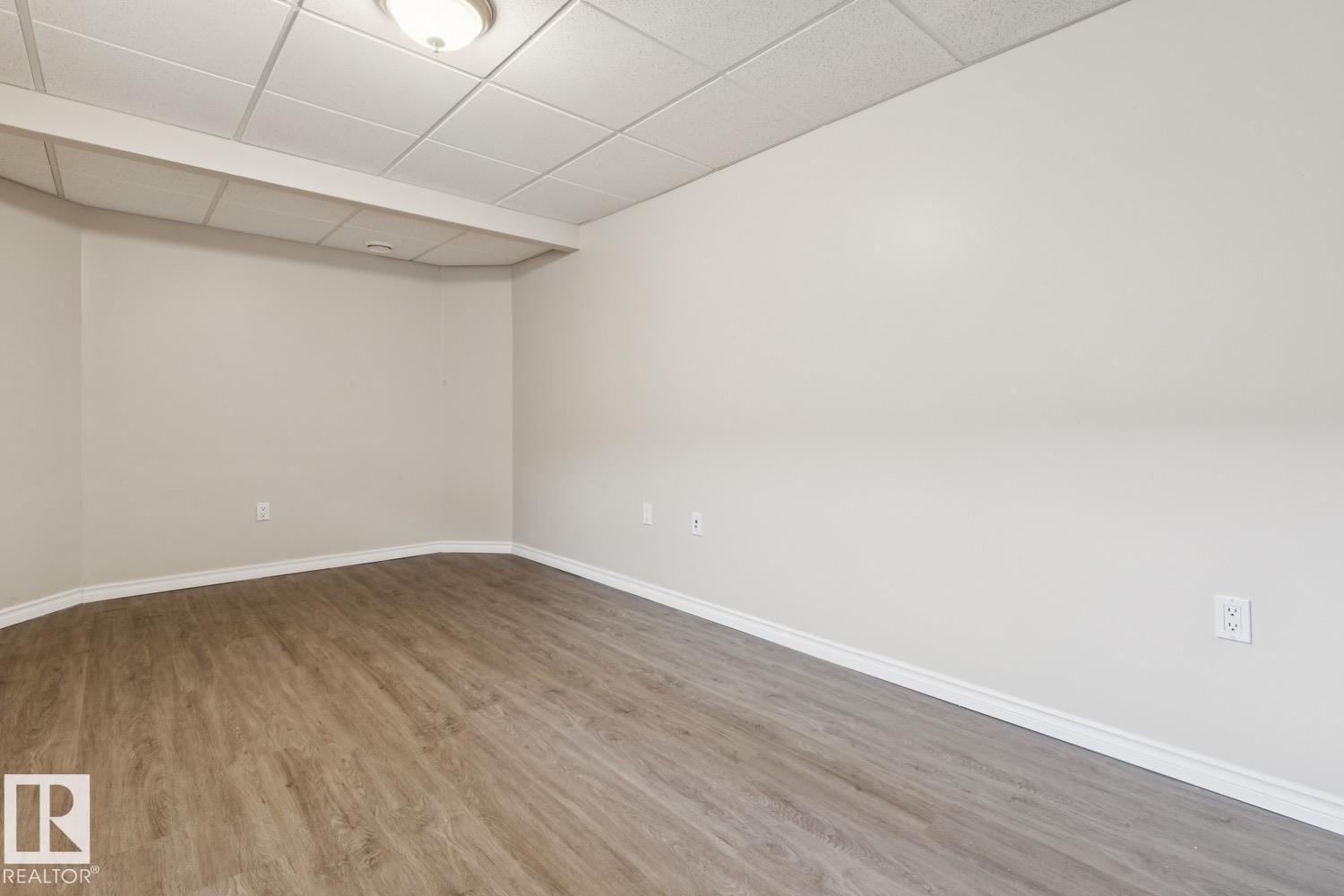Recessed ceiling with acoustic paneling, neutral wall finishes, wood-finish flooring, and white trim - 16765 119 Street Nw, Edmonton, AB