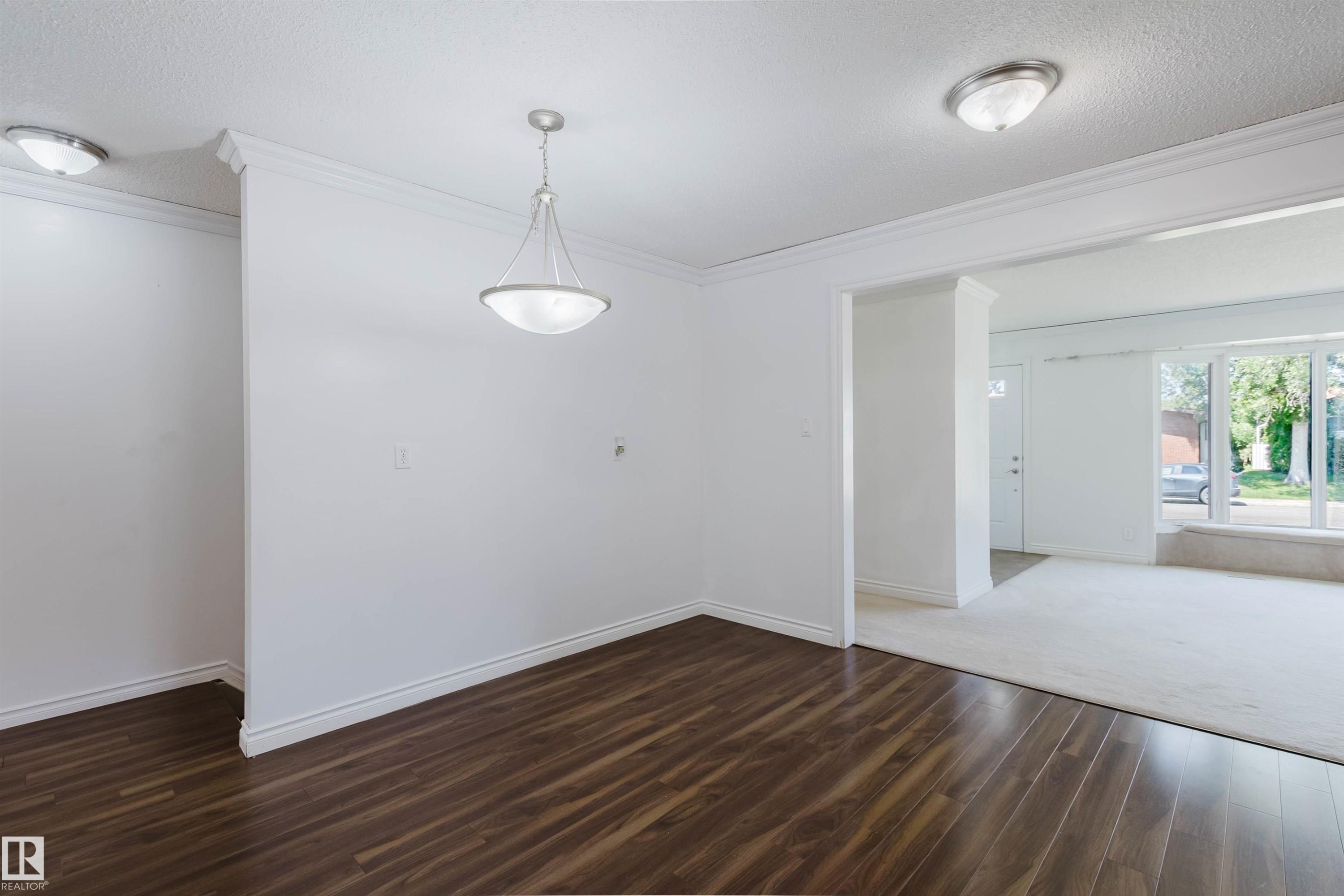 Open-concept interior featuring wood-finish flooring, white walls, and crown molding - 11115 39A Avenue Nw, Edmonton, AB - Indoor Photo Showing Other Room