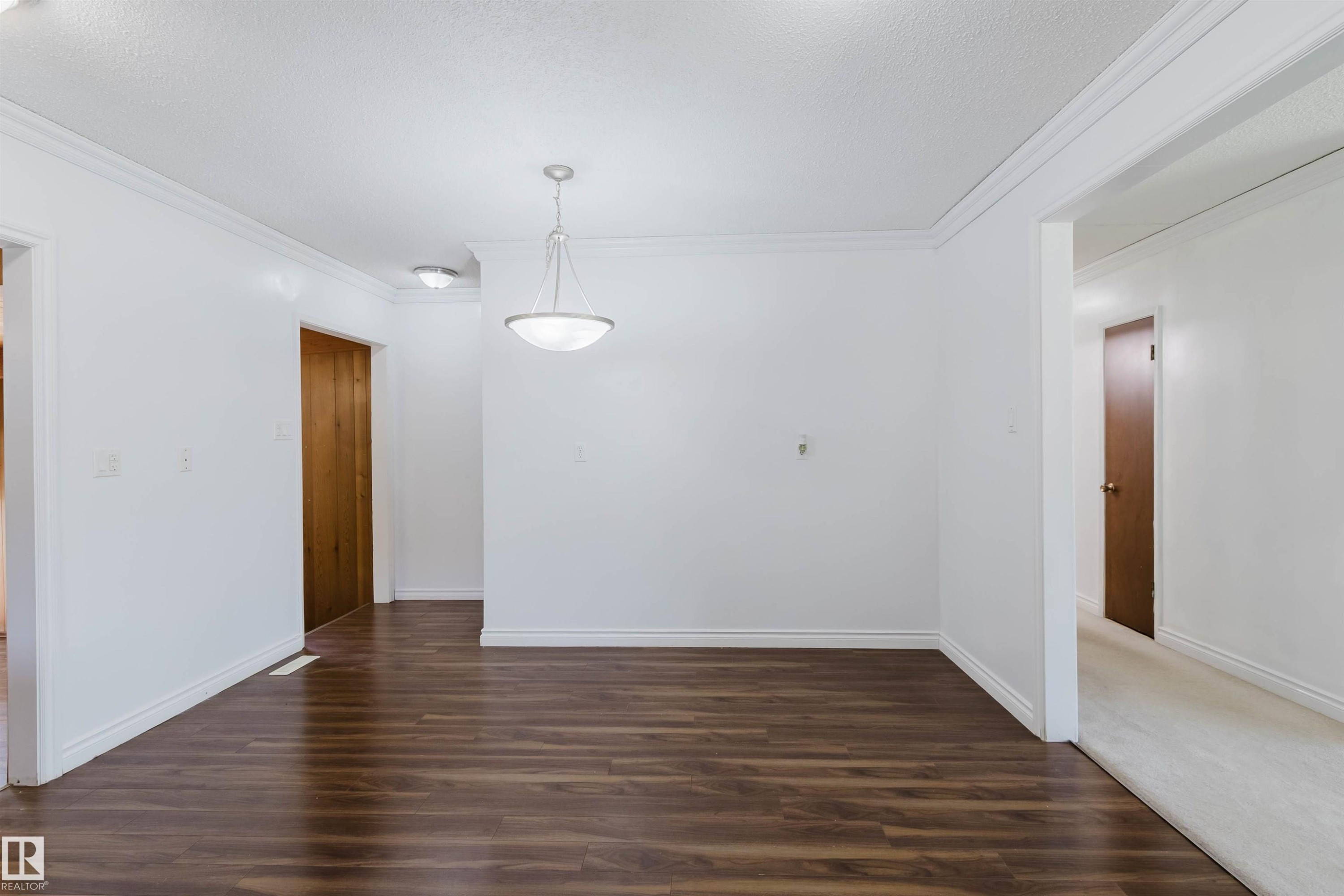 Spacious room featuring wood-finish flooring, white walls, and a ceiling-mounted light fixture - 11115 39A Avenue Nw, Edmonton, AB - Indoor Photo Showing Other Room