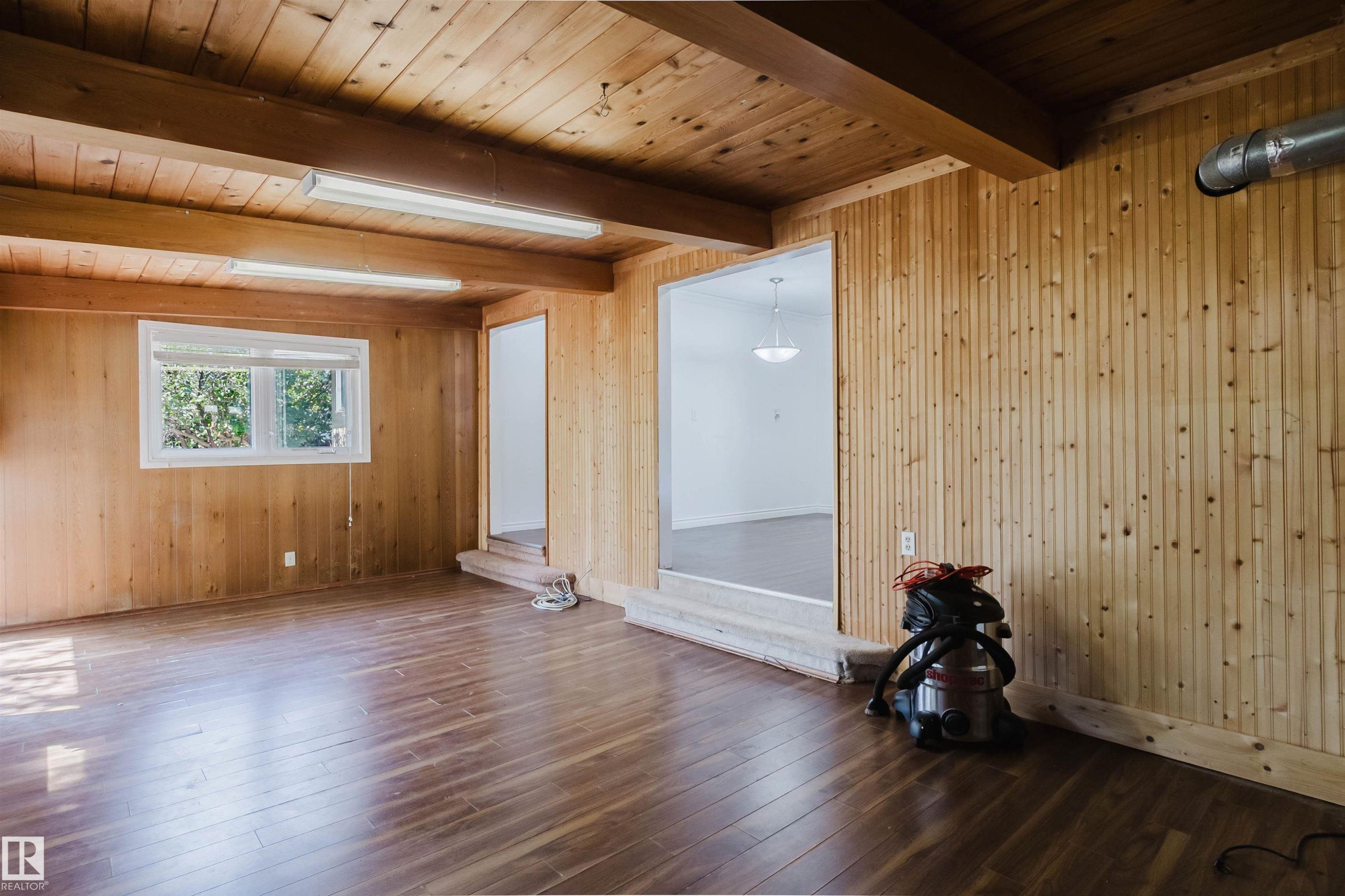 Wood-finish flooring with natural wood paneling throughout the walls and ceiling - 11115 39A Avenue Nw, Edmonton, AB - Indoor Photo Showing Other Room