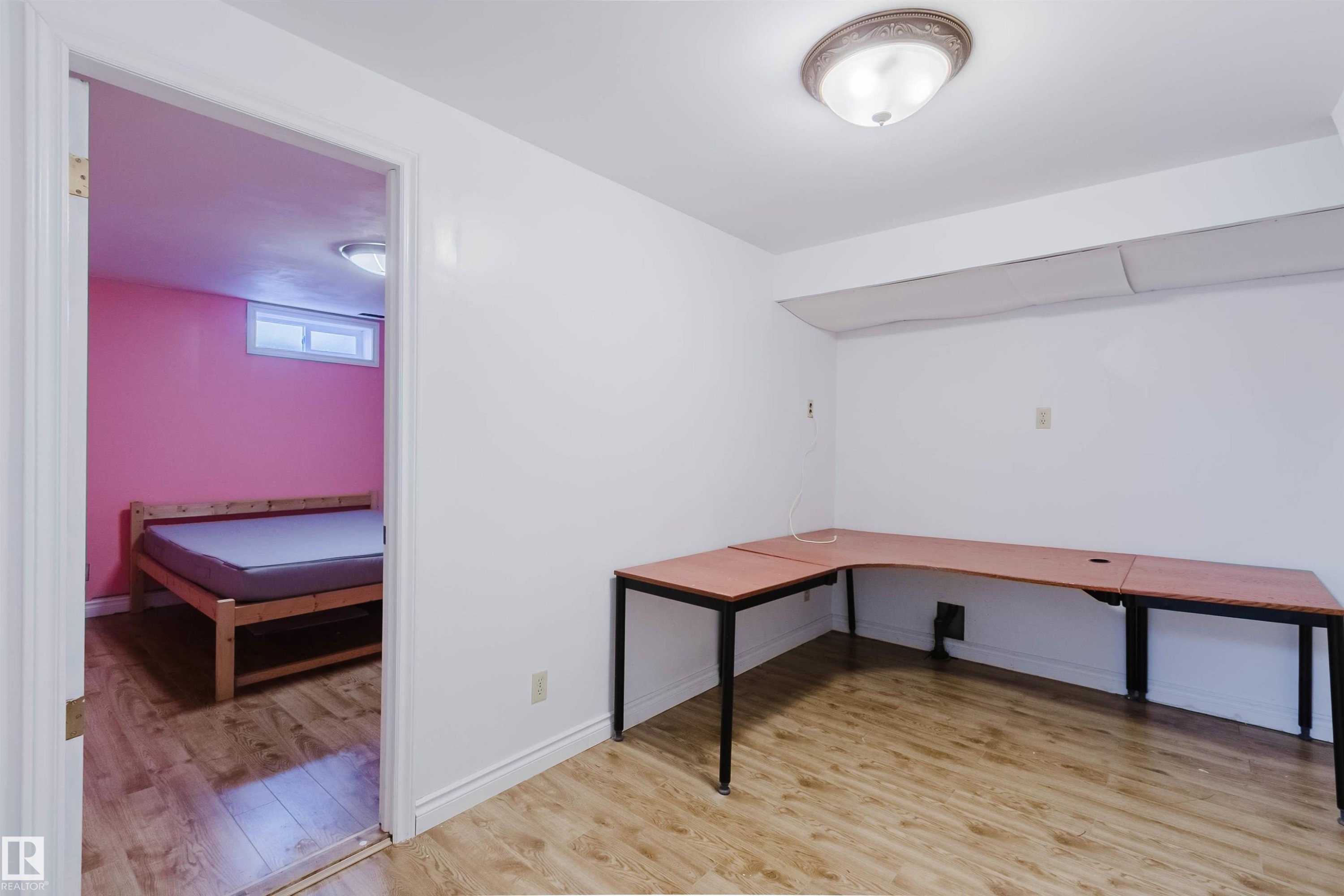 Interior room featuring wood-finish flooring, white walls, and an overhead flush-mount light fixture - 11115 39A Avenue Nw, Edmonton, AB - Indoor Photo Showing Other Room