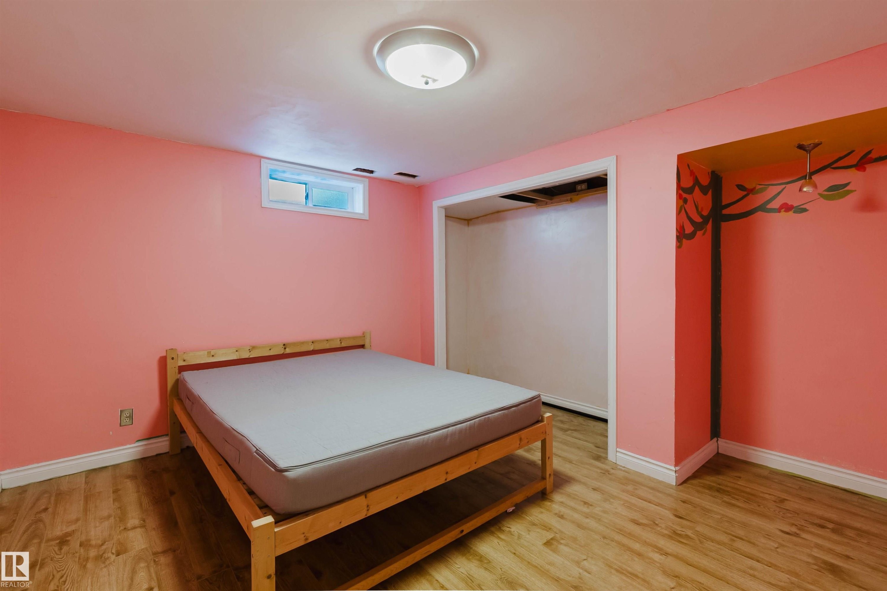 Room featuring wood-finish flooring, a flush-mount ceiling light fixture, and a high window - 11115 39A Avenue Nw, Edmonton, AB - Indoor