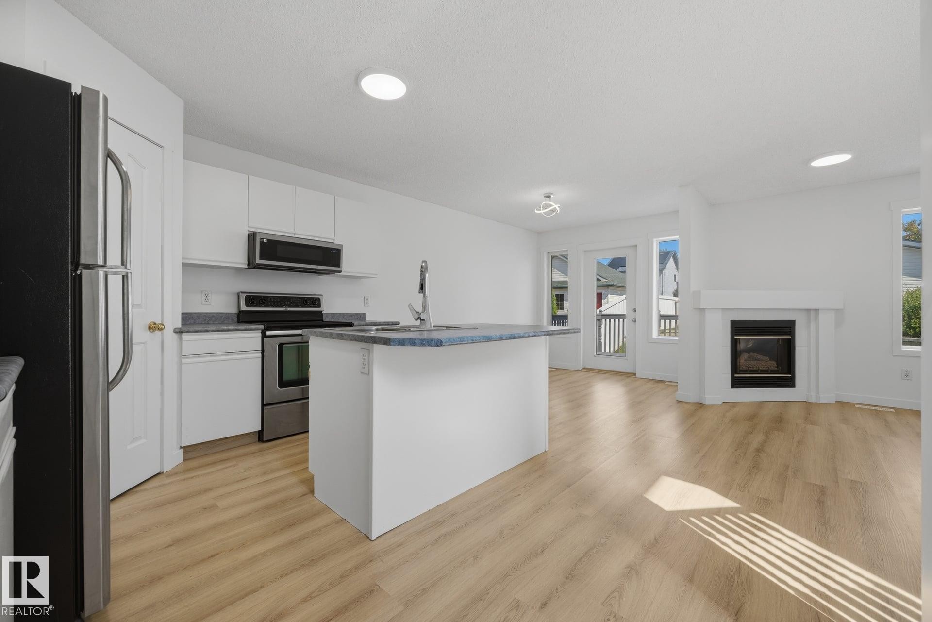 2076 Tanner Wynd Nw, Edmonton, AB - Indoor Photo Showing Kitchen With Fireplace With Stainless Steel Kitchen