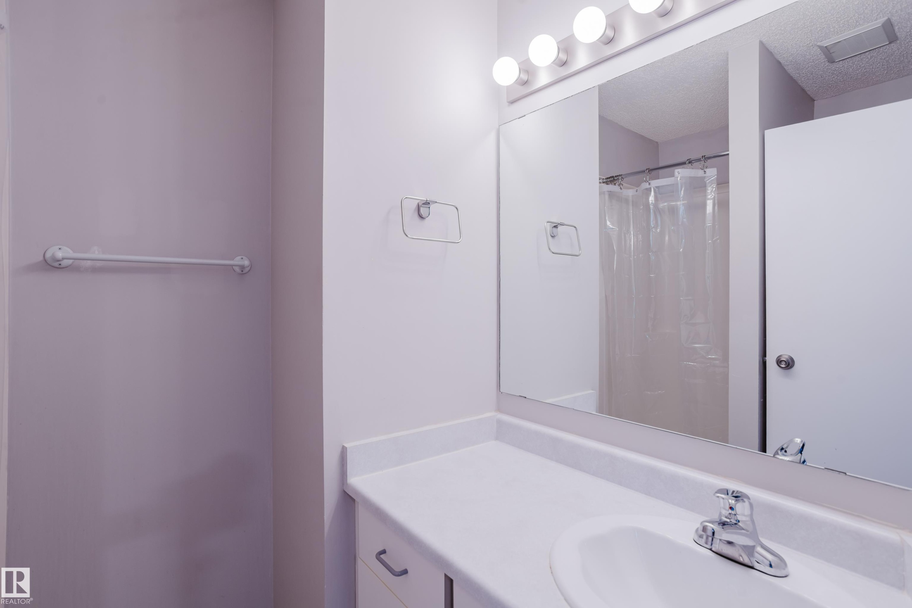 Bathroom vanity featuring a white countertop, integrated sink, and chrome faucet - 337 Pearson Crescent Nw, Edmonton, AB - Indoor Photo Showing Bathroom