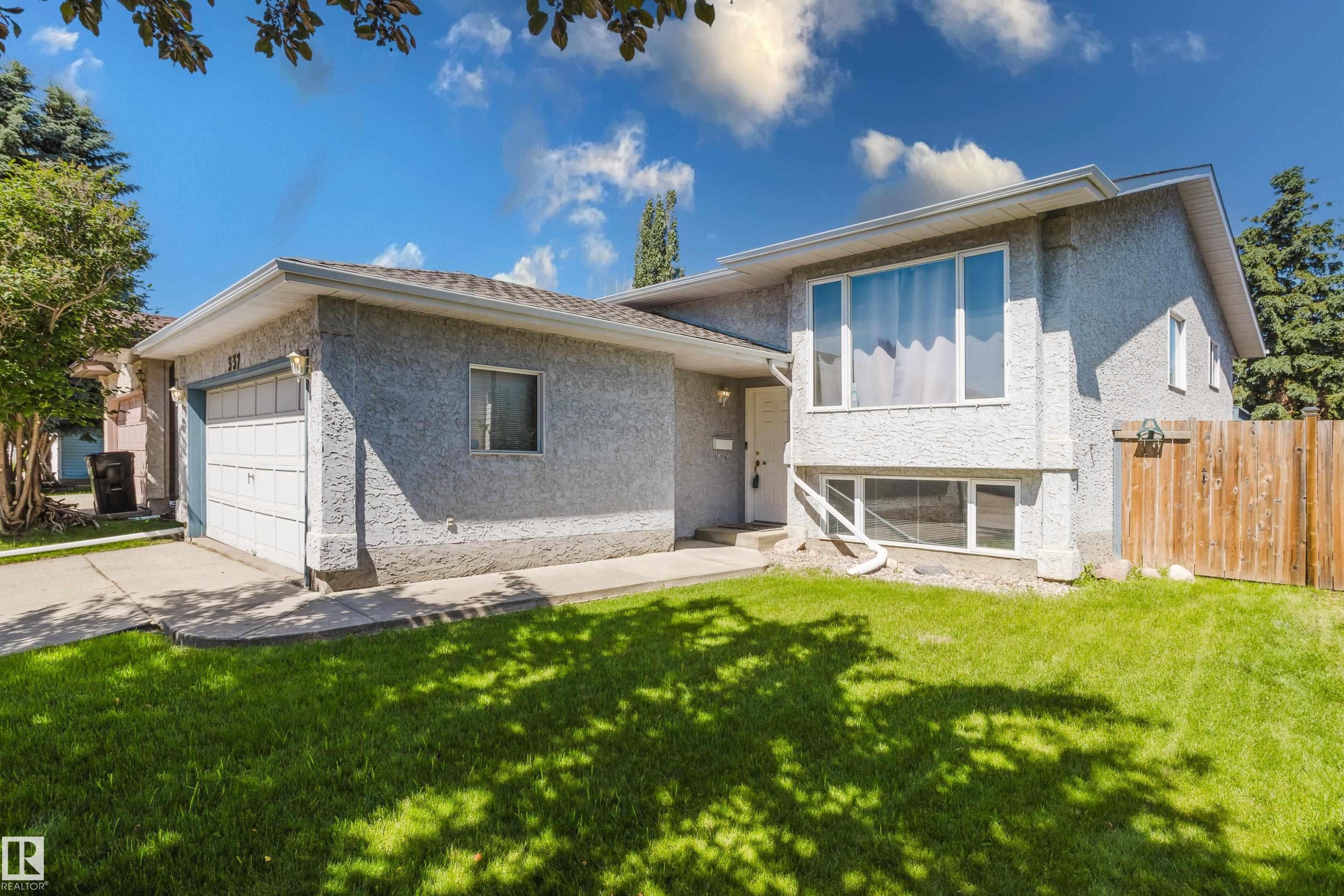 Stucco exterior residence featuring a front lawn and paved driveway - 337 Pearson Crescent Nw, Edmonton, AB - Outdoor