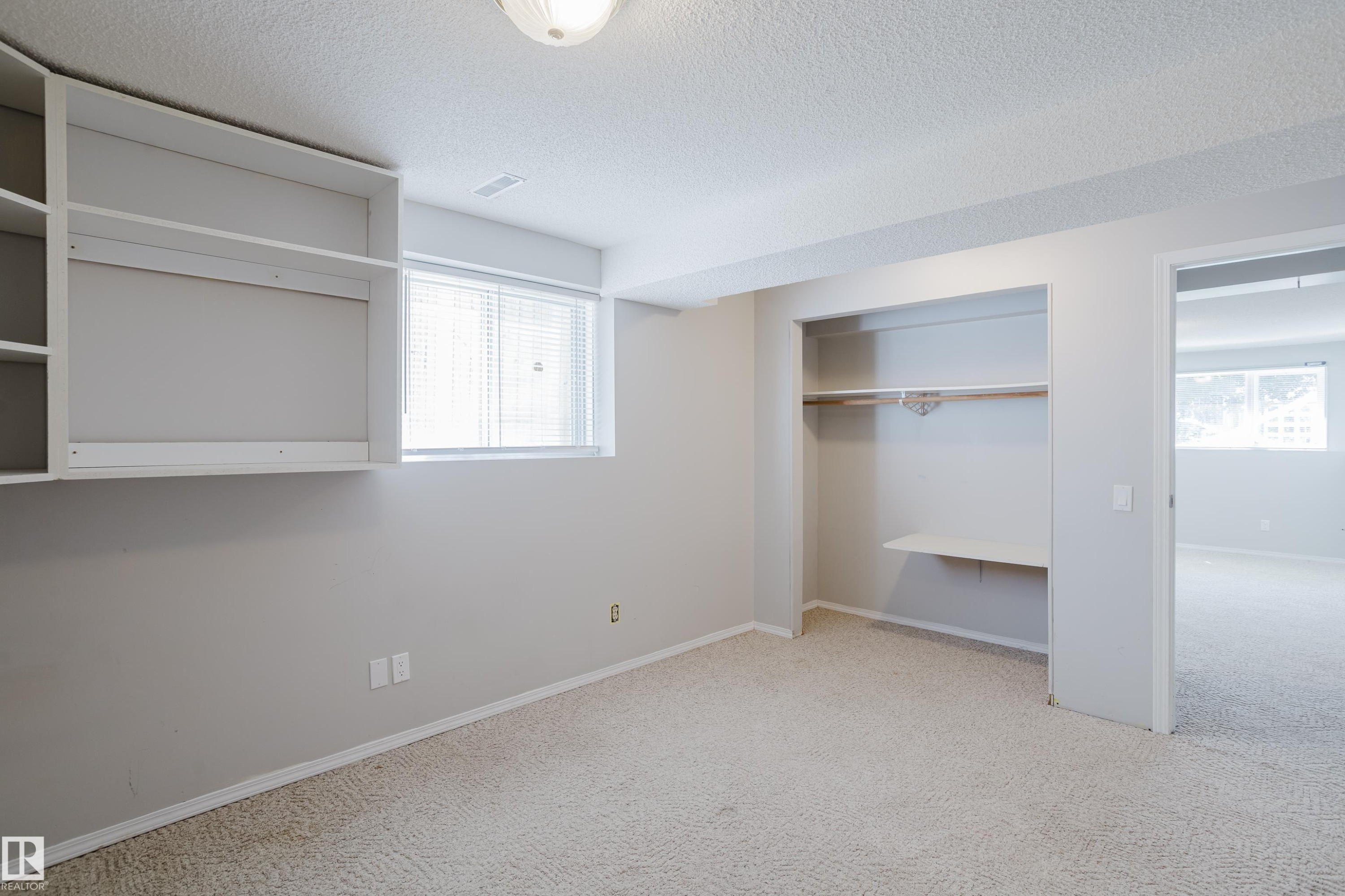 Room featuring built-in shelving, a window with blinds, and a built-in closet with a hanging rod and shelf - 337 Pearson Crescent Nw, Edmonton, AB - Indoor Photo Showing Other Room