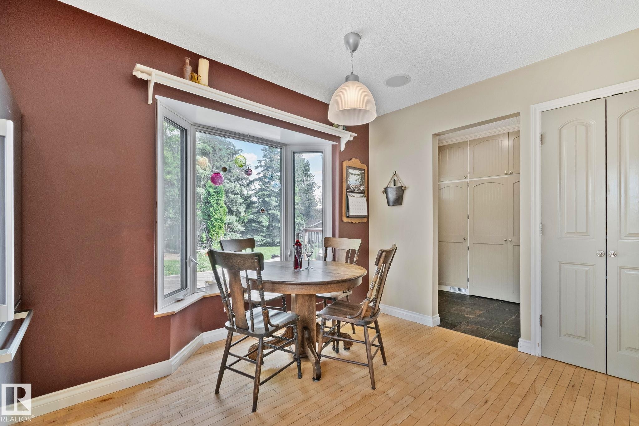 Bay window with exterior views, light wood-finish flooring, and a contemporary ceiling light fixture - 7306 21 Avenue Nw, Edmonton, AB - Indoor Photo Showing Dining Room
