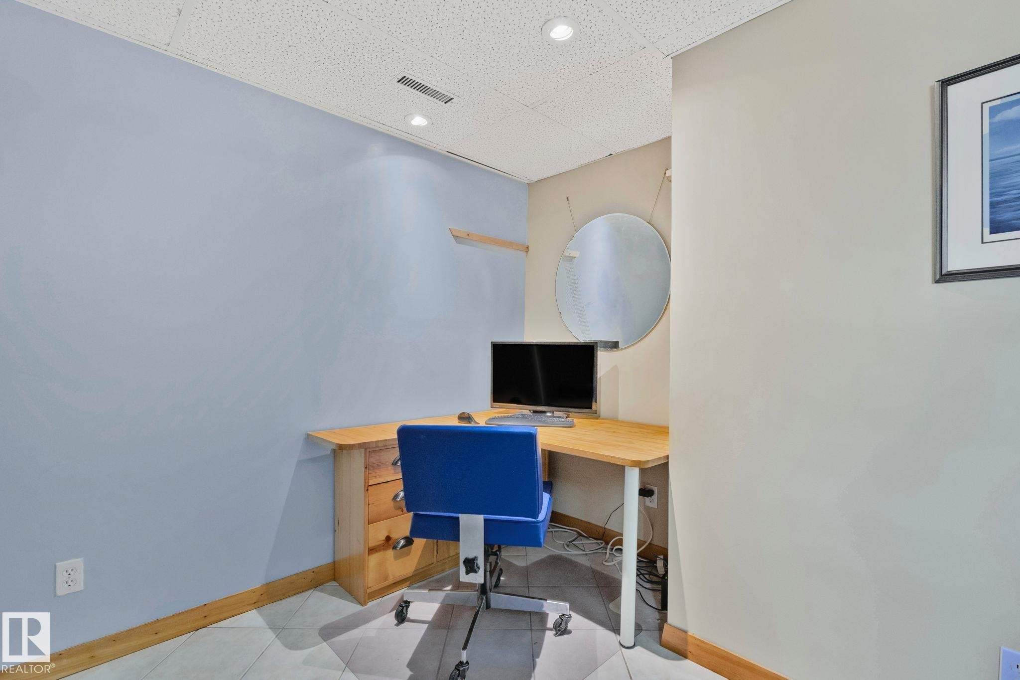 Integrated corner desk with wood-finish top and built-in drawers - 7306 21 Avenue Nw, Edmonton, AB - Indoor Photo Showing Office