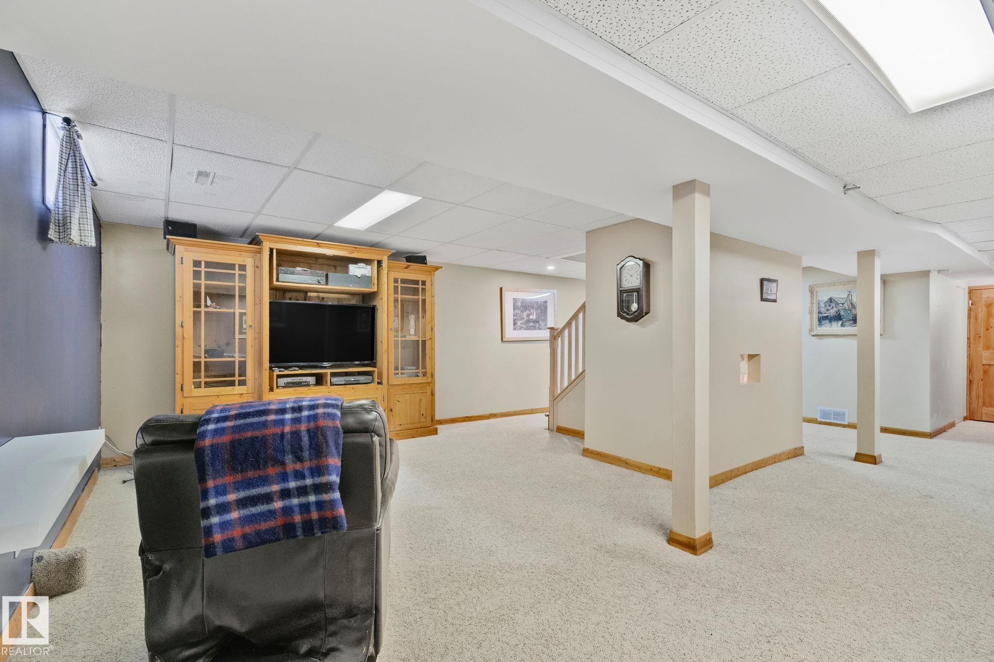 Spacious lower-level area with light-toned carpet flooring, recessed lighting, and drop ceiling panels - 7306 21 Avenue Nw, Edmonton, AB - Indoor Photo Showing Basement