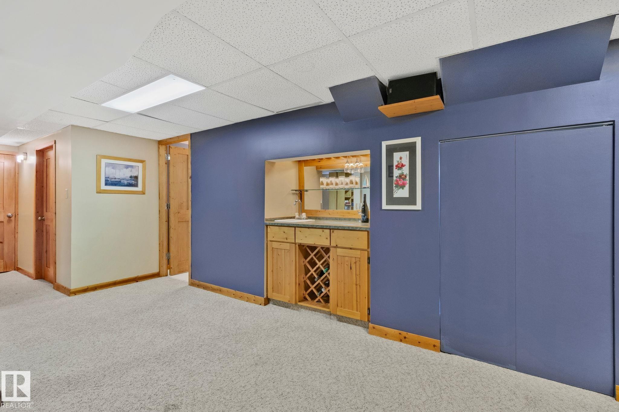Built-in wet bar featuring a stone-finish countertop, wood cabinetry, and integrated wine storage - 7306 21 Avenue Nw, Edmonton, AB - Indoor