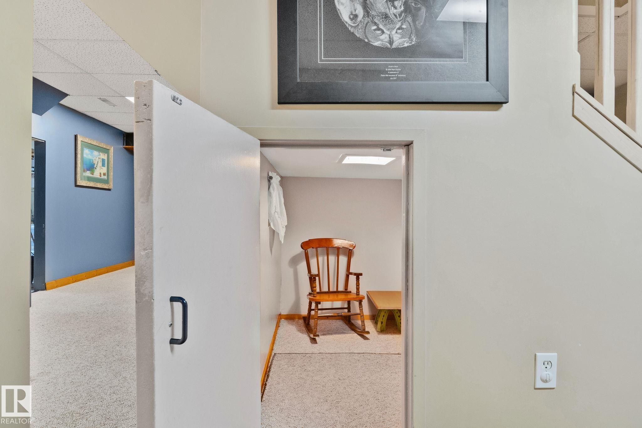 White door with a black handle providing access to an interior room with carpet flooring and an overhead light - 7306 21 Avenue Nw, Edmonton, AB - Indoor Photo Showing Other Room