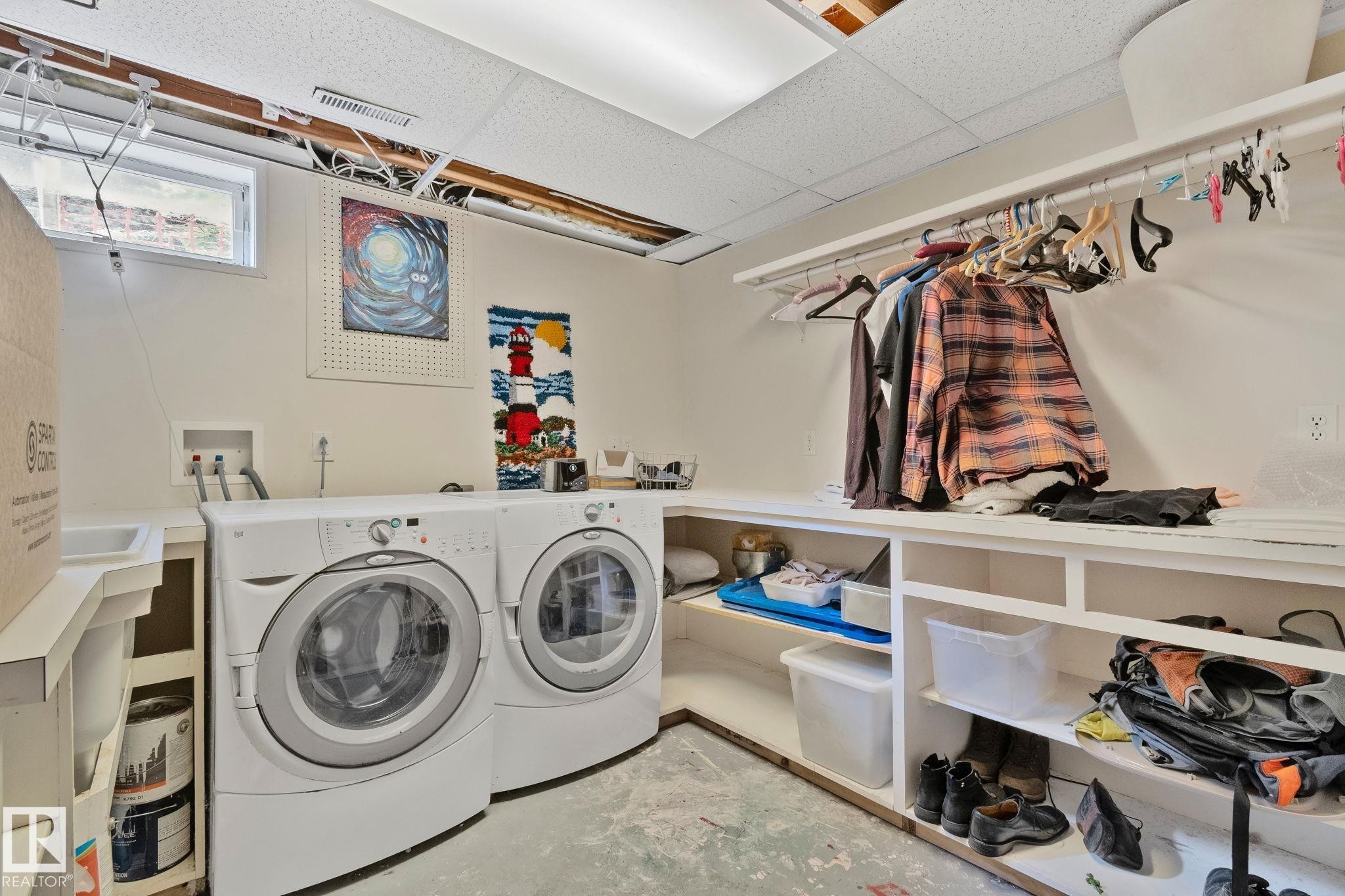 Dedicated laundry area featuring a front-loading washer and dryer, utility sink, counter space, built-in shelving, and clothes hanging rod - 7306 21 Avenue Nw, Edmonton, AB - Indoor Photo Showing Laundry Room