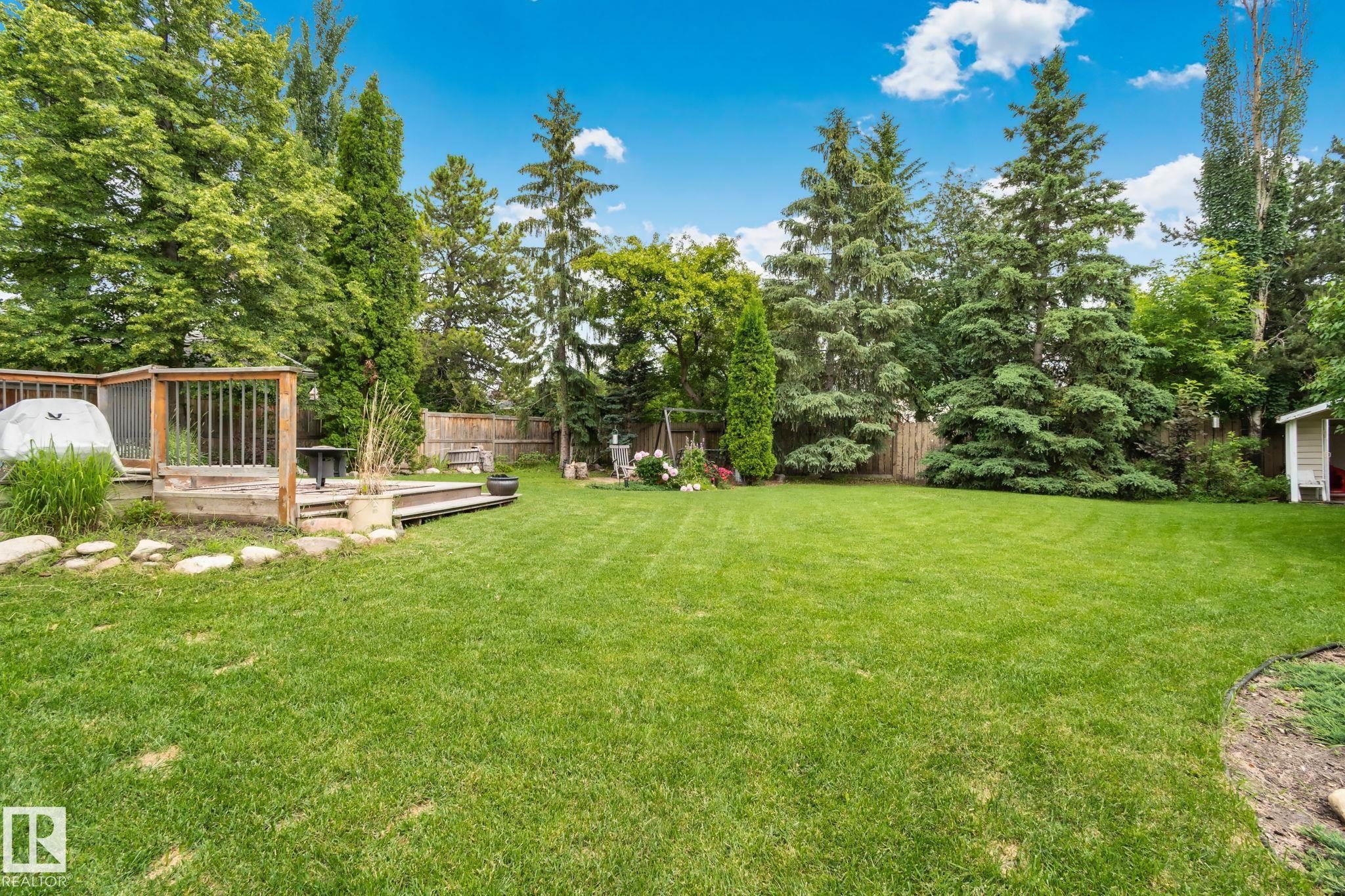 Expansive green lawn with a multi-level wood deck and mature trees - 7306 21 Avenue Nw, Edmonton, AB - Outdoor