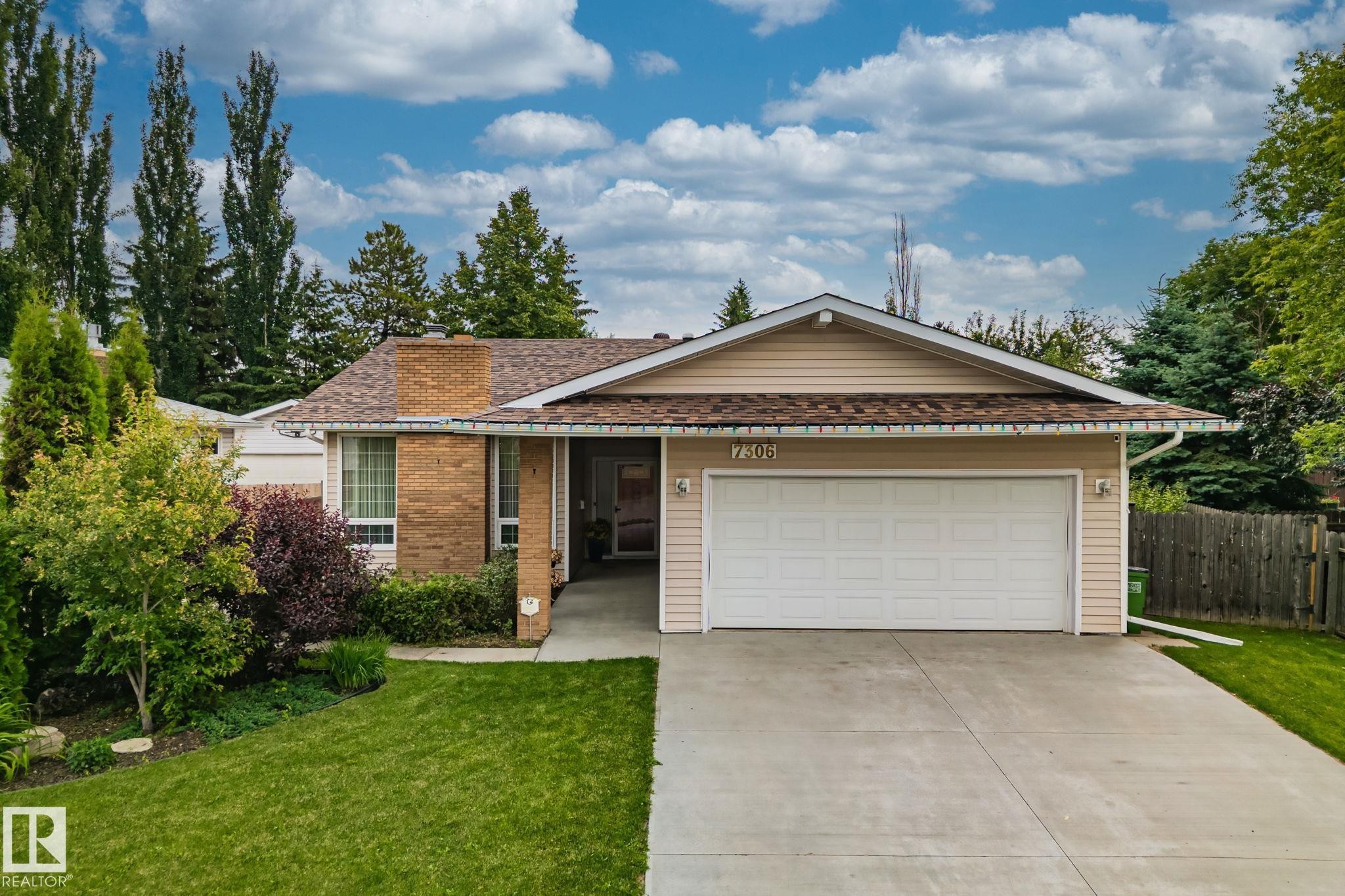 Single-story residence featuring a two-car garage, concrete driveway, and brick and siding exterior - 7306 21 Avenue Nw, Edmonton, AB - Outdoor