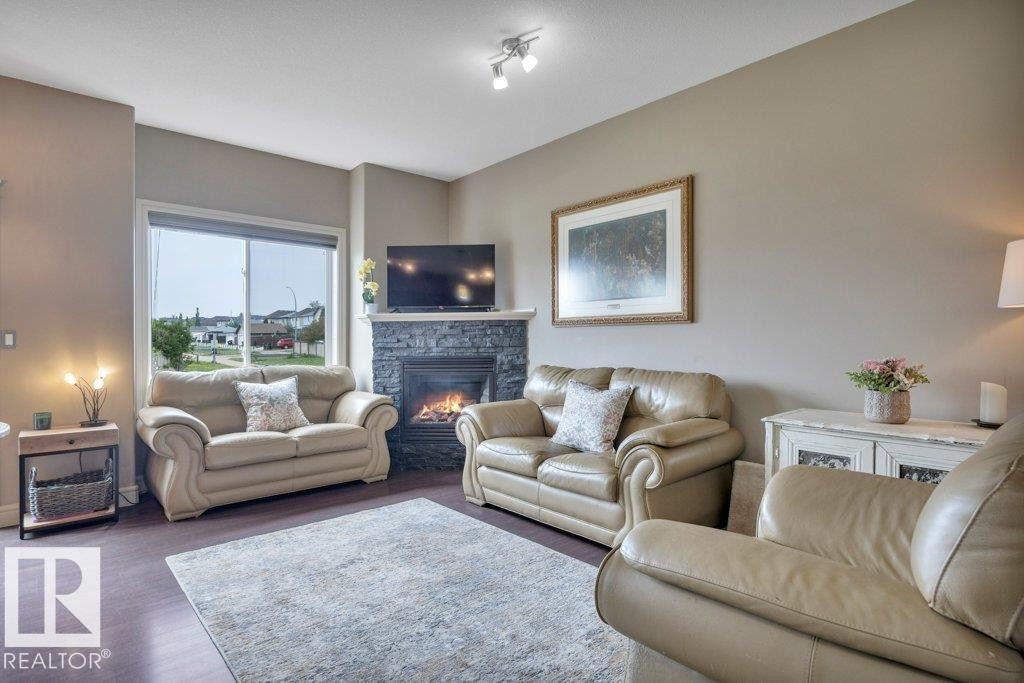With corner gas fireplace - #10 15151 43 St Nw, Edmonton, AB - Indoor Photo Showing Living Room With Fireplace