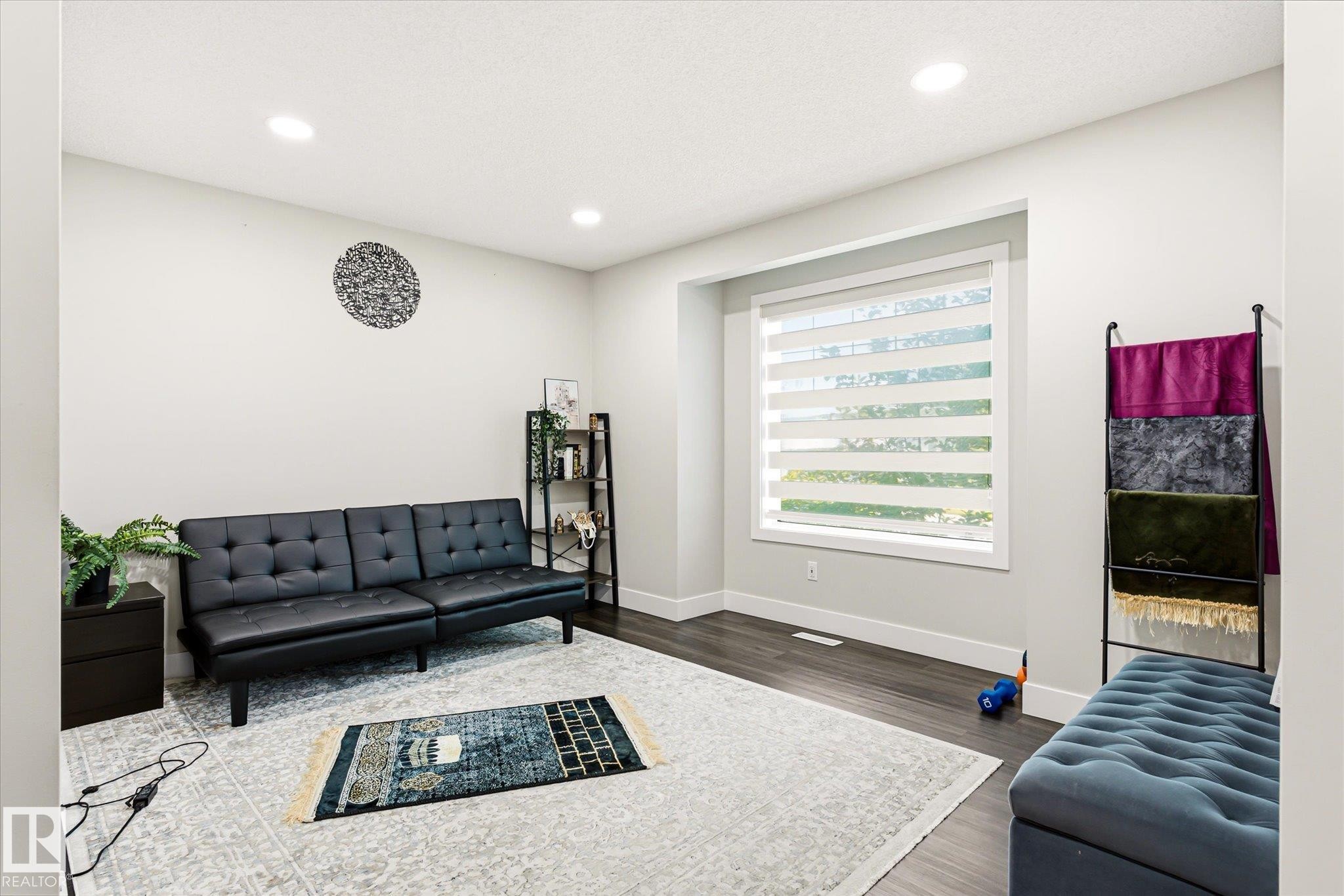 Bright room featuring recessed lighting, a large window with horizontal blinds, dark wood-finish flooring, and white baseboards - 4317 152 Avenue Nw, Edmonton, AB - Indoor Photo Showing Living Room