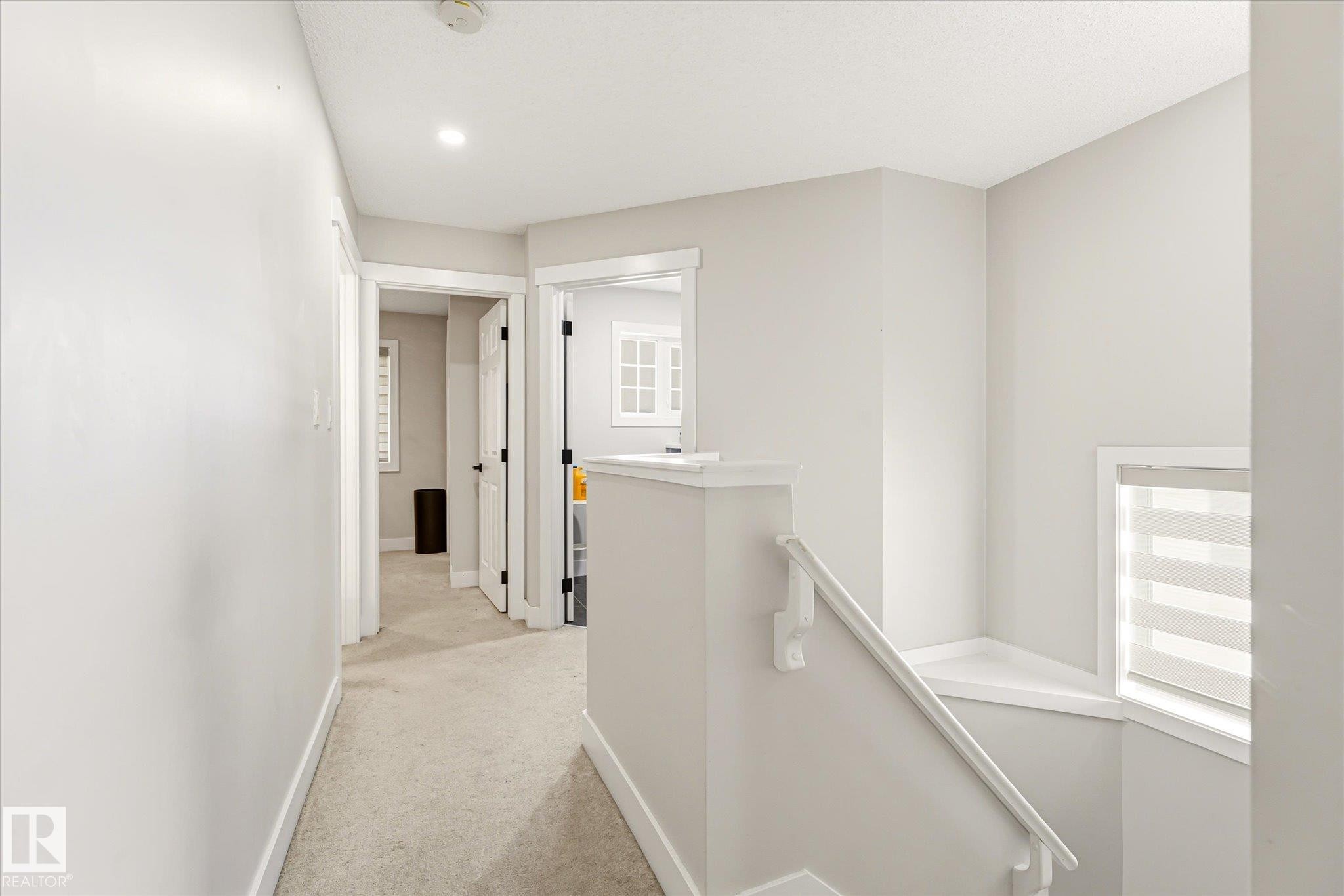 Upper level hallway featuring light gray walls, white trim, and recessed lighting - 4317 152 Avenue Nw, Edmonton, AB - Indoor Photo Showing Other Room