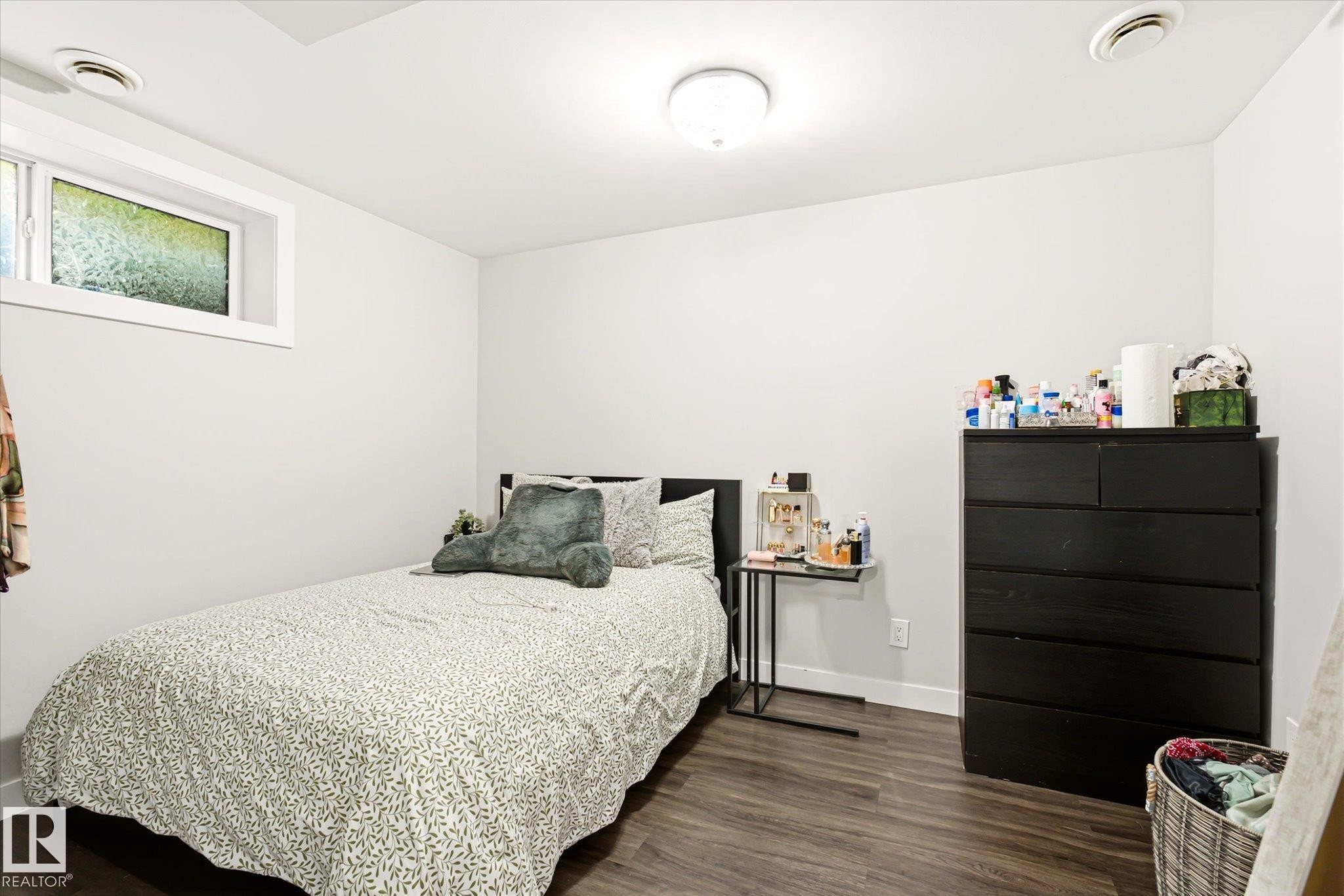 Room with wood-finish flooring, white walls, and a recessed window - 4317 152 Avenue Nw, Edmonton, AB - Indoor Photo Showing Bedroom