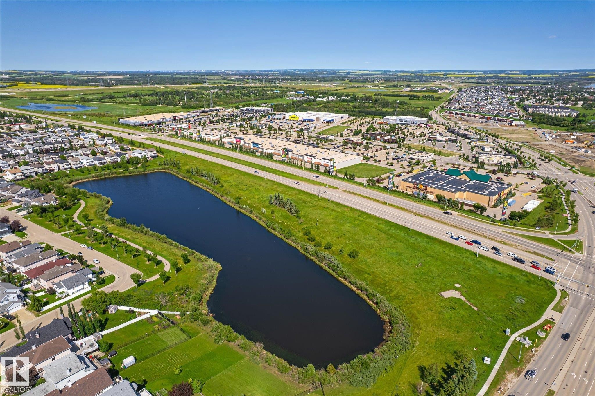 Expansive aerial capturing a neighborhood with varied residential structures and a large body of water - 4317 152 Avenue Nw, Edmonton, AB - Outdoor With View