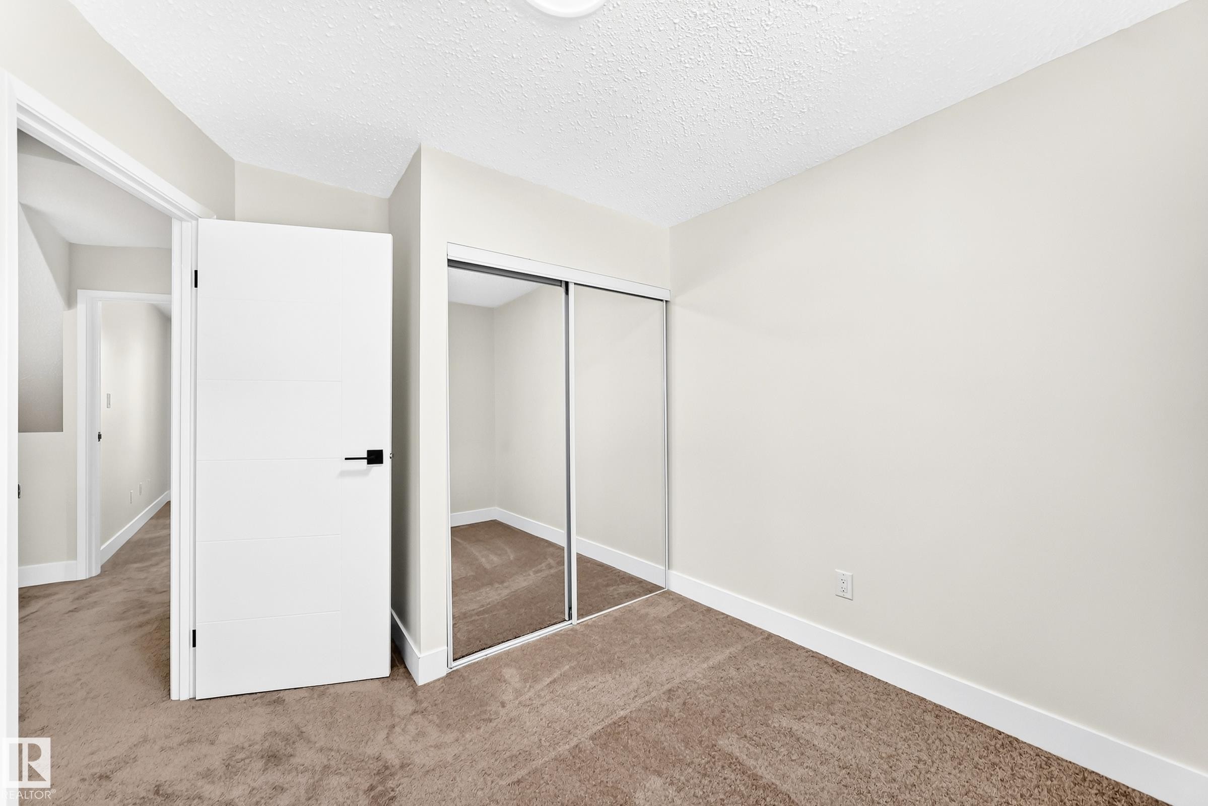 Room featuring neutral wall tones, textured carpet, and a flush-mount ceiling light - 3119 144 Avenue Nw, Edmonton, AB - Indoor Photo Showing Other Room