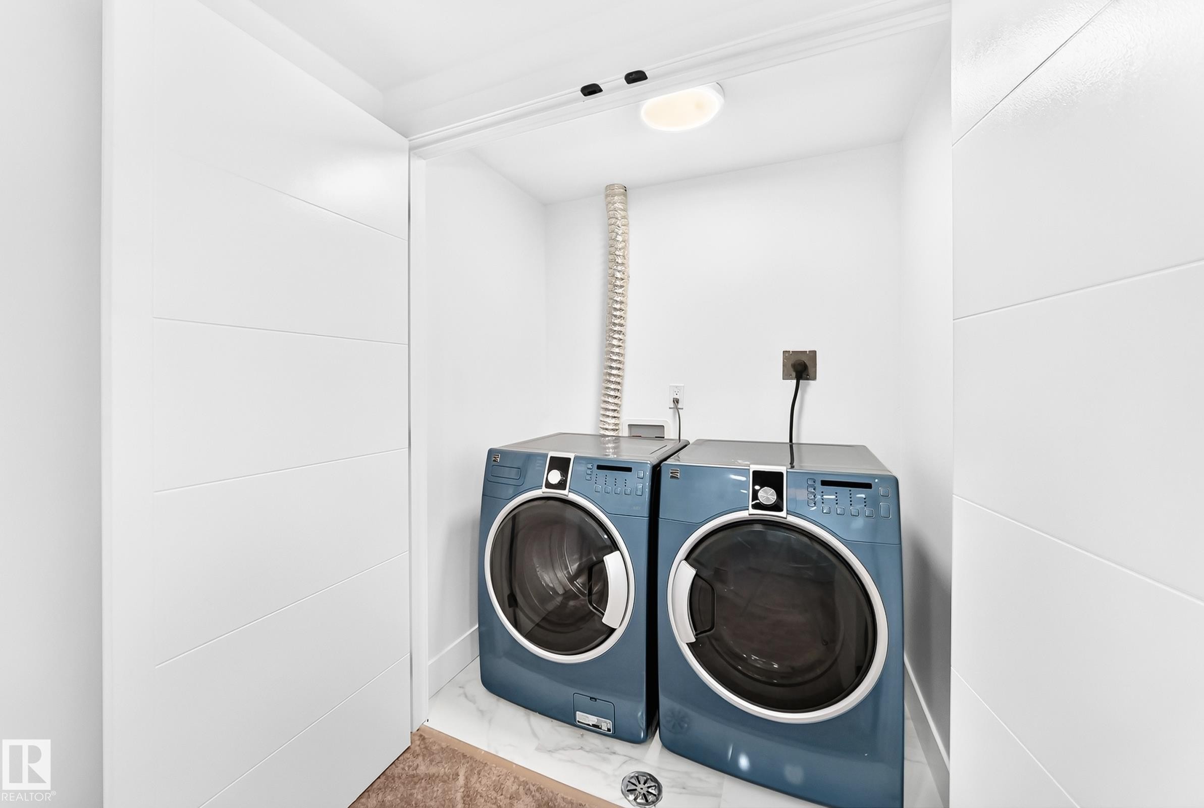 Dedicated laundry area featuring white panel doors, white walls, overhead lighting, and a tiled floor - 3119 144 Avenue Nw, Edmonton, AB - Indoor Photo Showing Laundry Room