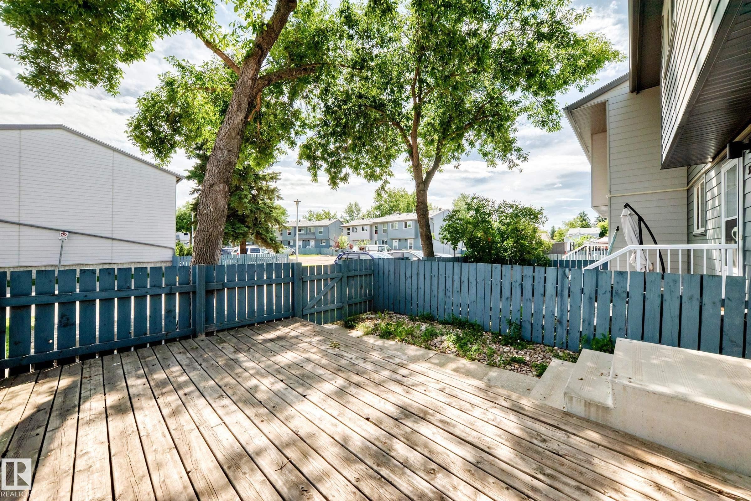 Spacious wood-finish deck with a painted wooden fence - 3119 144 Avenue Nw, Edmonton, AB - Outdoor With Deck Patio Veranda With Exterior