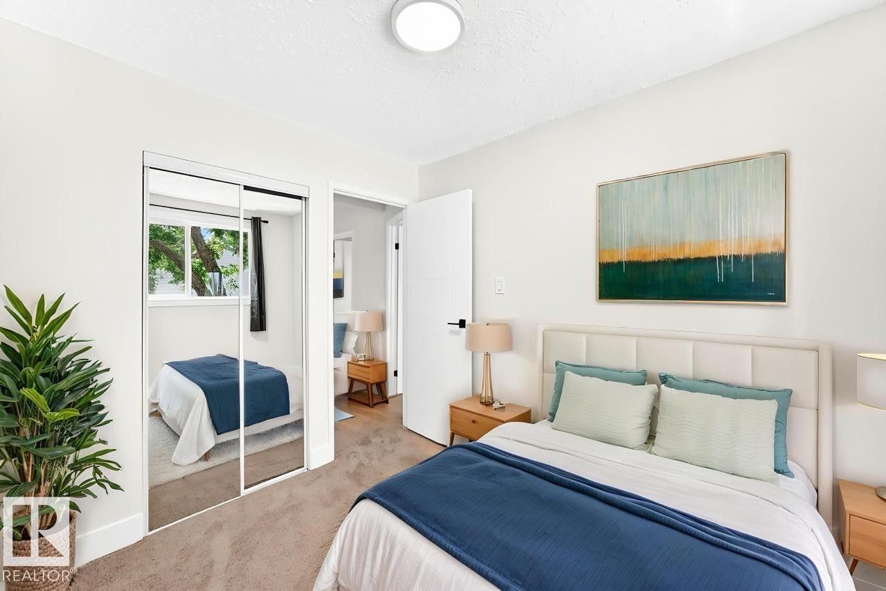 Bedroom featuring plush carpet flooring, a built-in mirrored closet, and a neutral color palette - 3119 144 Avenue Nw, Edmonton, AB - Indoor Photo Showing Bedroom