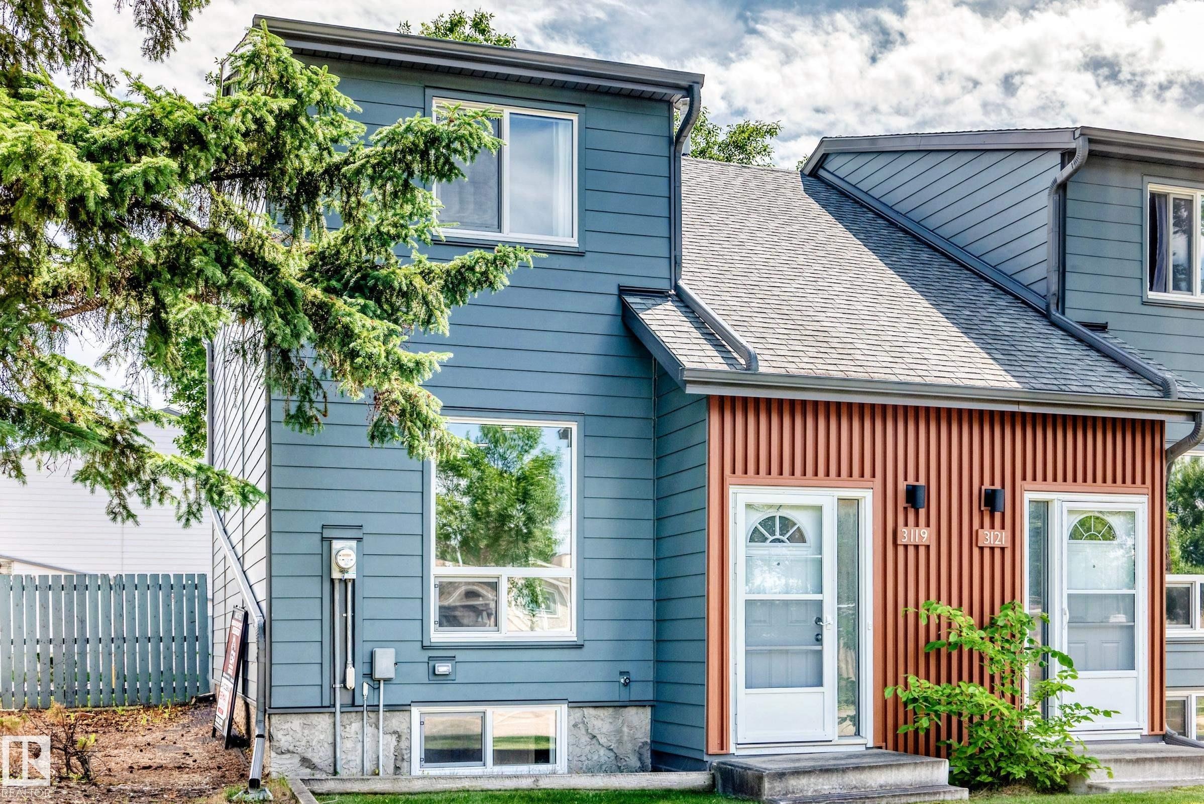 Contemporary exterior featuring blue horizontal siding and vertical wood-look accent panels - 3119 144 Avenue Nw, Edmonton, AB - Outdoor