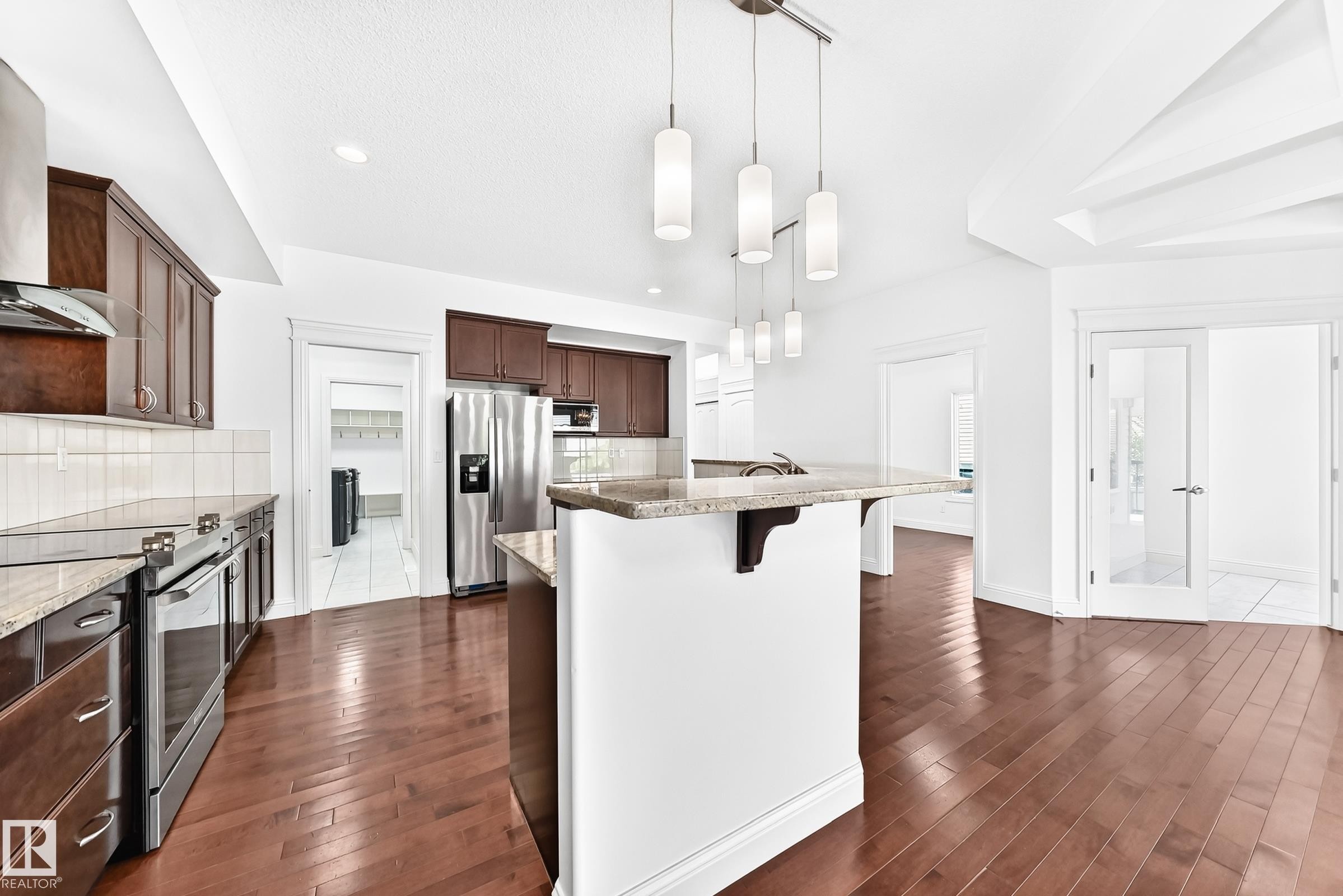 Kitchen featuring rich wood cabinetry, stainless steel appliances, and granite countertops - 1663 Rutherford Road Sw, Edmonton, AB - Indoor Photo Showing Kitchen With Stainless Steel Kitchen With Upgraded Kitchen