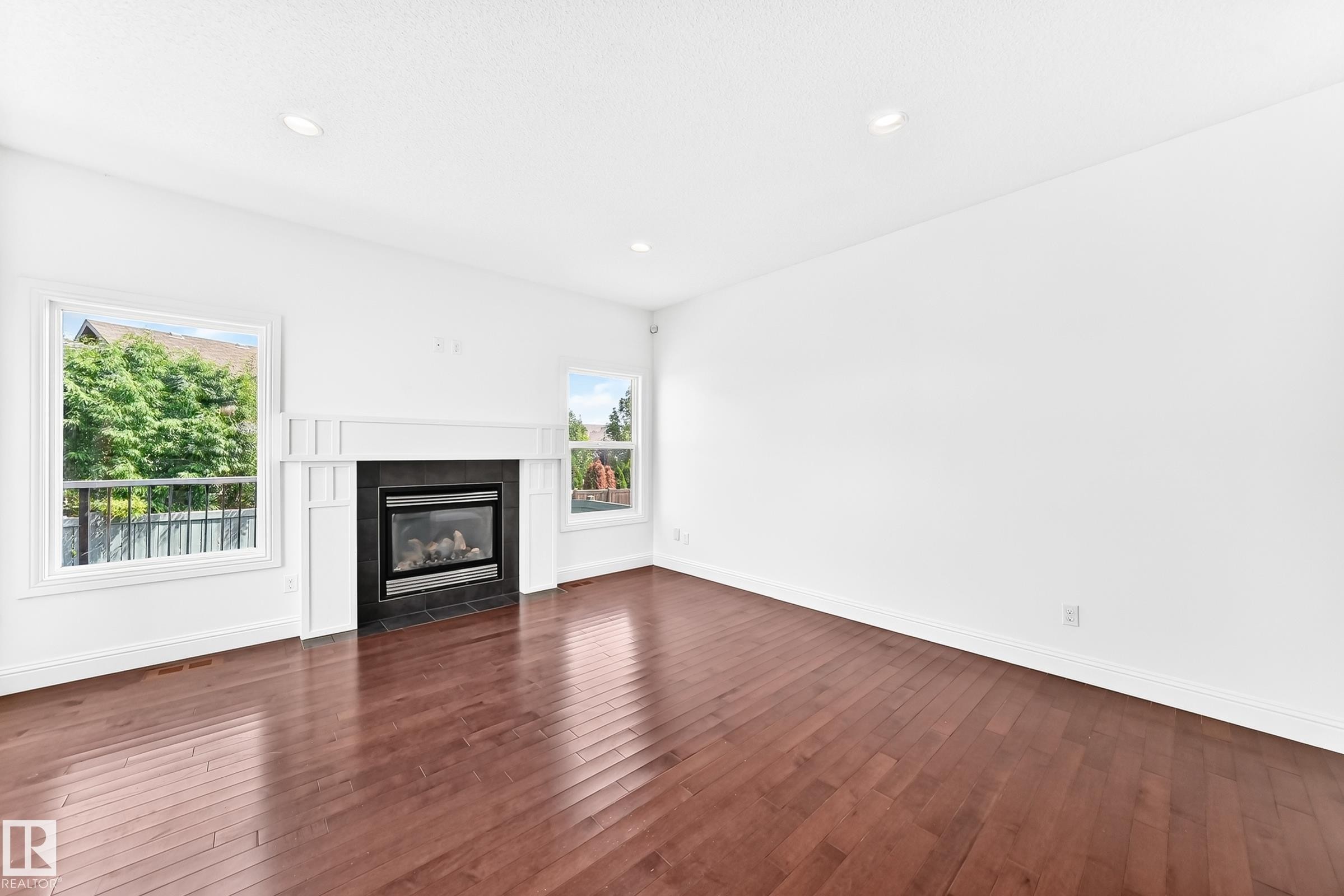 Living area featuring rich wood-finish flooring and recessed lighting - 1663 Rutherford Road Sw, Edmonton, AB - Indoor Photo Showing Living Room With Fireplace
