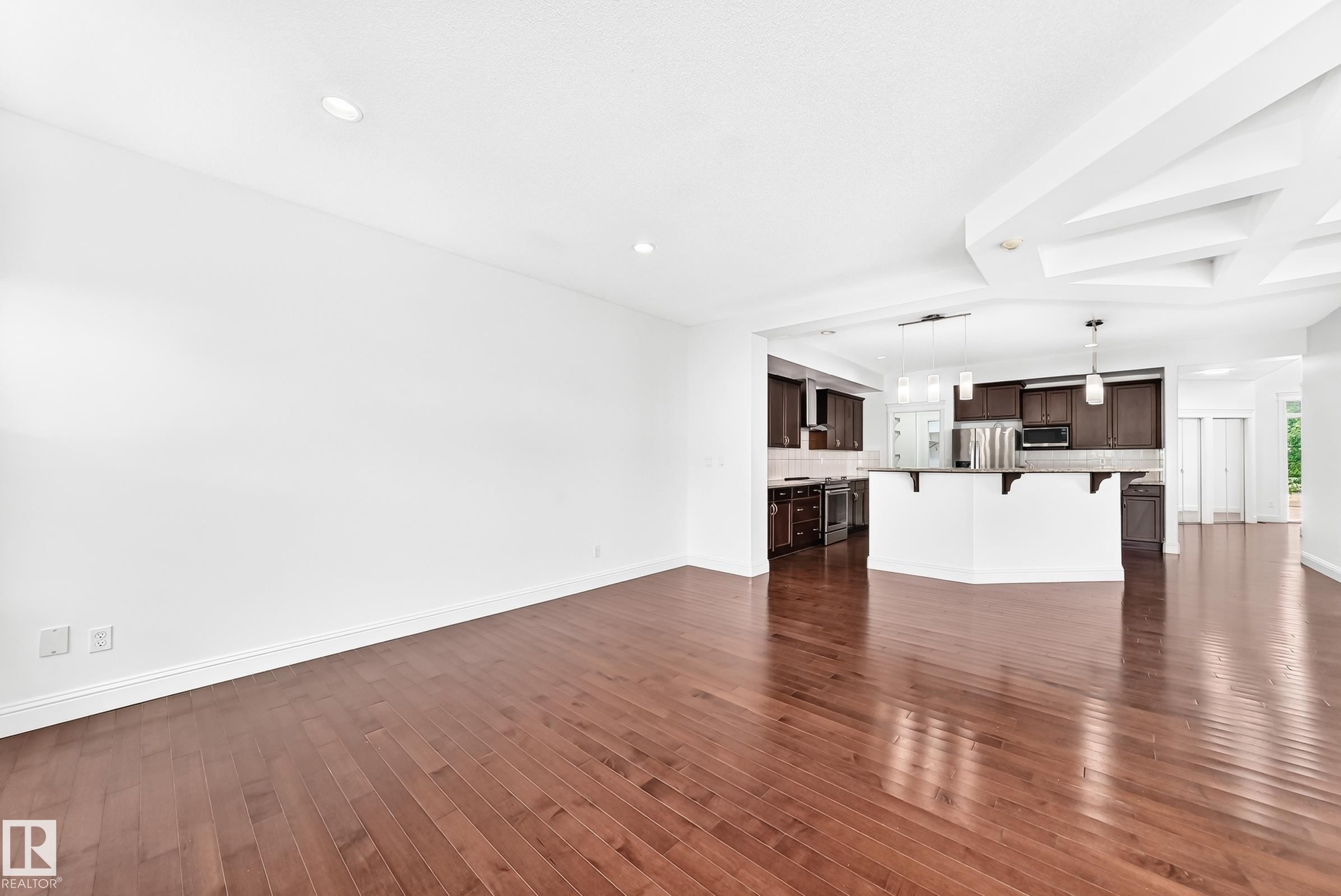 Open-concept living space featuring wood-finish flooring and recessed lighting - 1663 Rutherford Road Sw, Edmonton, AB - Indoor