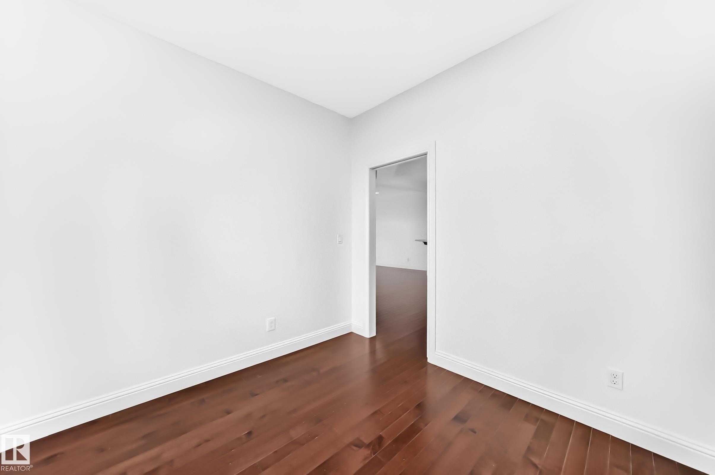 Room featuring rich wood-finish flooring and bright white walls - 1663 Rutherford Road Sw, Edmonton, AB - Indoor Photo Showing Other Room