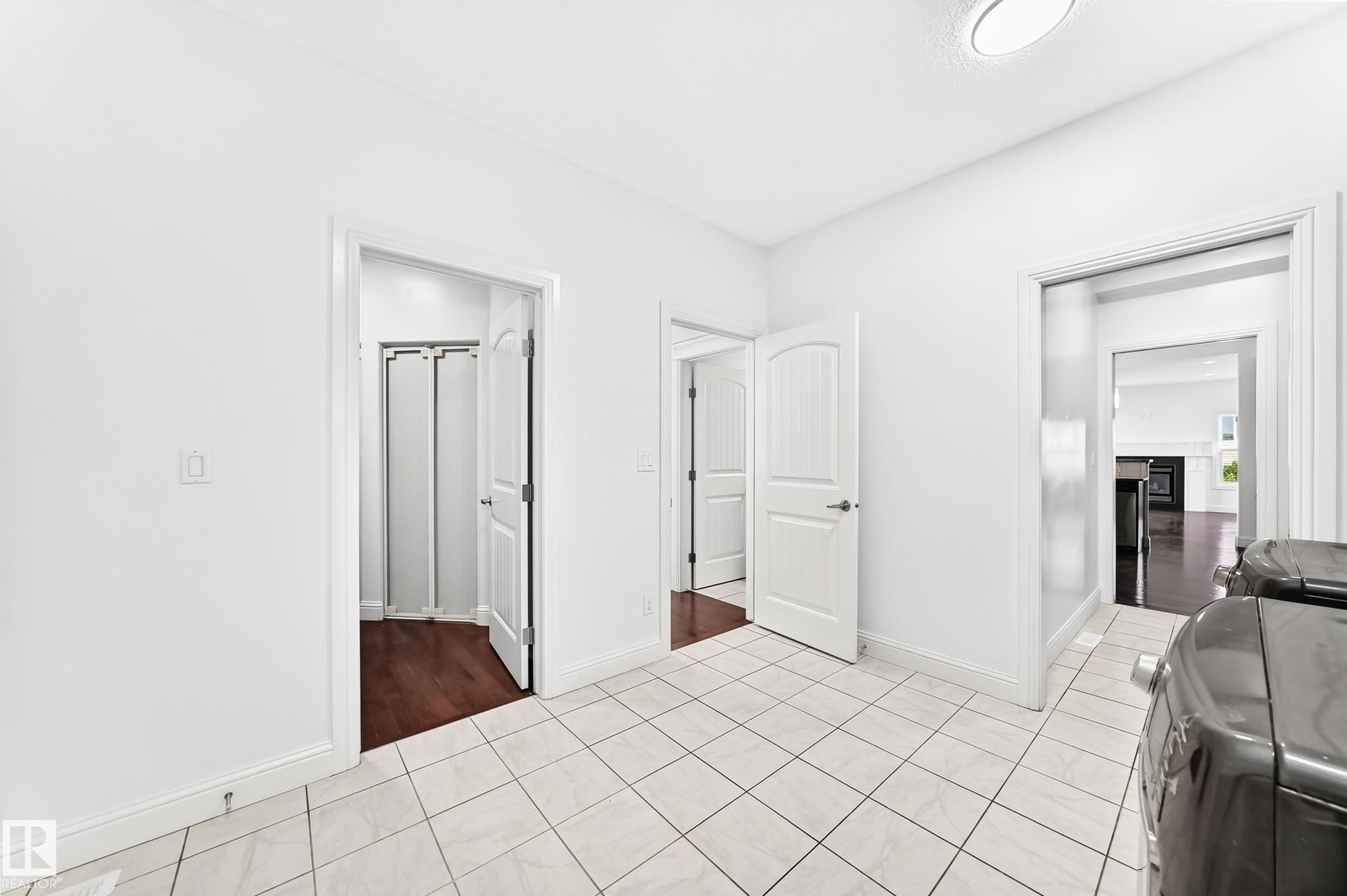 Utility area featuring white tile flooring and multiple entryways - 1663 Rutherford Road Sw, Edmonton, AB - Indoor Photo Showing Other Room