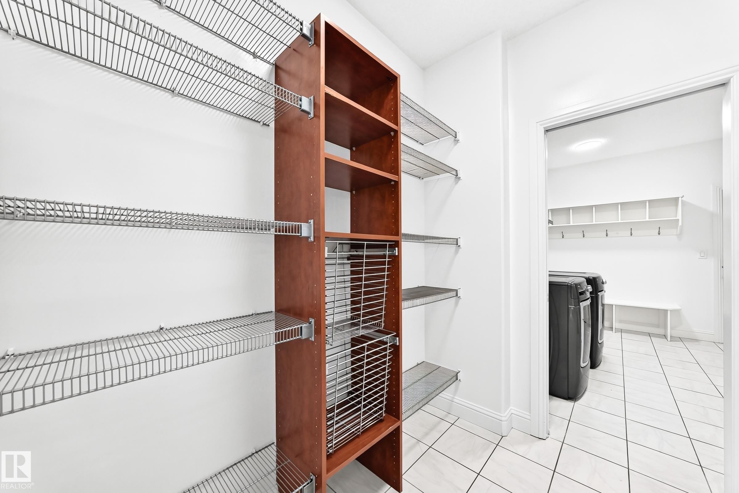 Customizable wire shelving system with a wood-finish storage unit, offering ample organization - 1663 Rutherford Road Sw, Edmonton, AB - Indoor With Storage