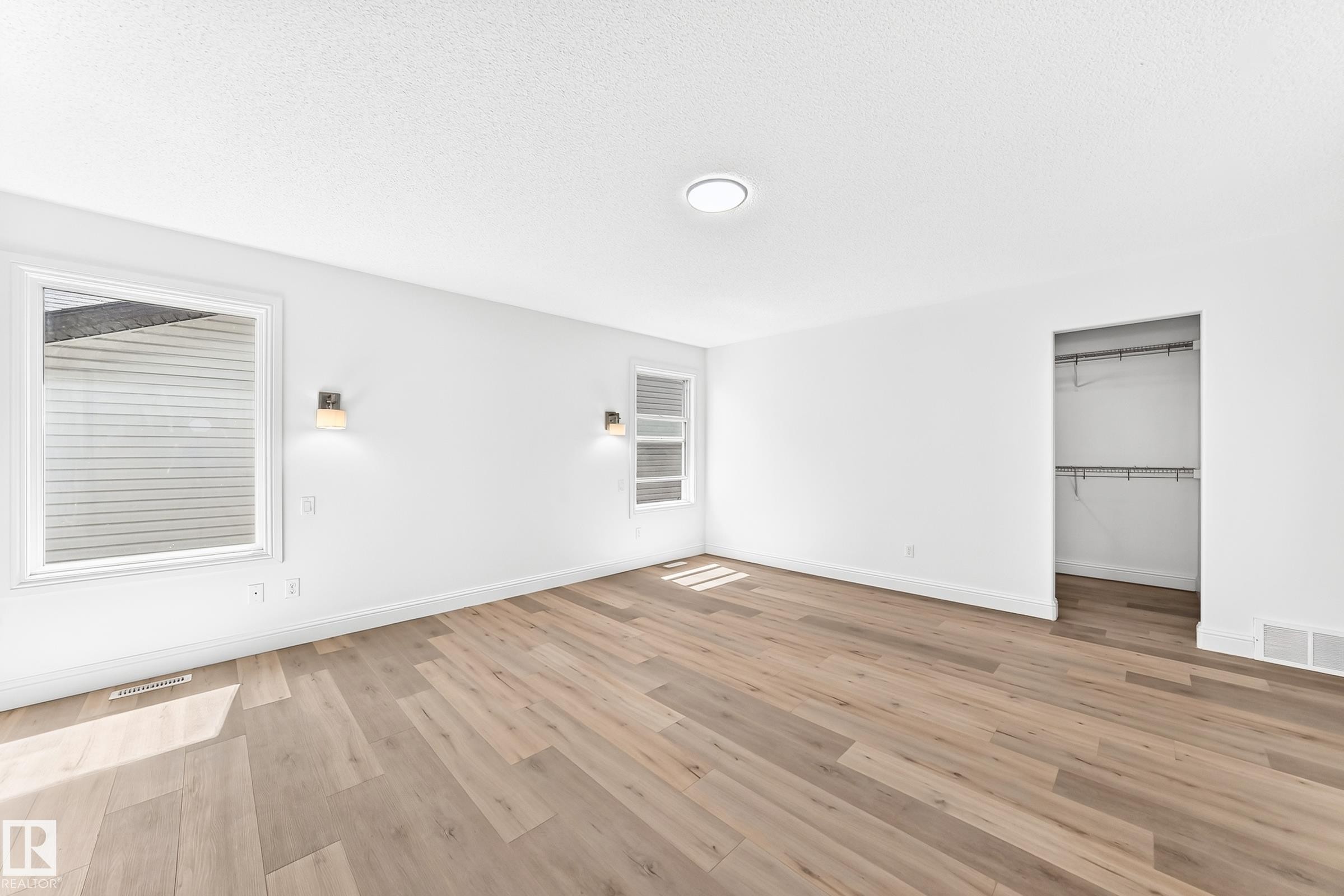 Spacious room featuring light wood-finish flooring, white walls, and a clean white ceiling - 1663 Rutherford Road Sw, Edmonton, AB - Indoor Photo Showing Other Room