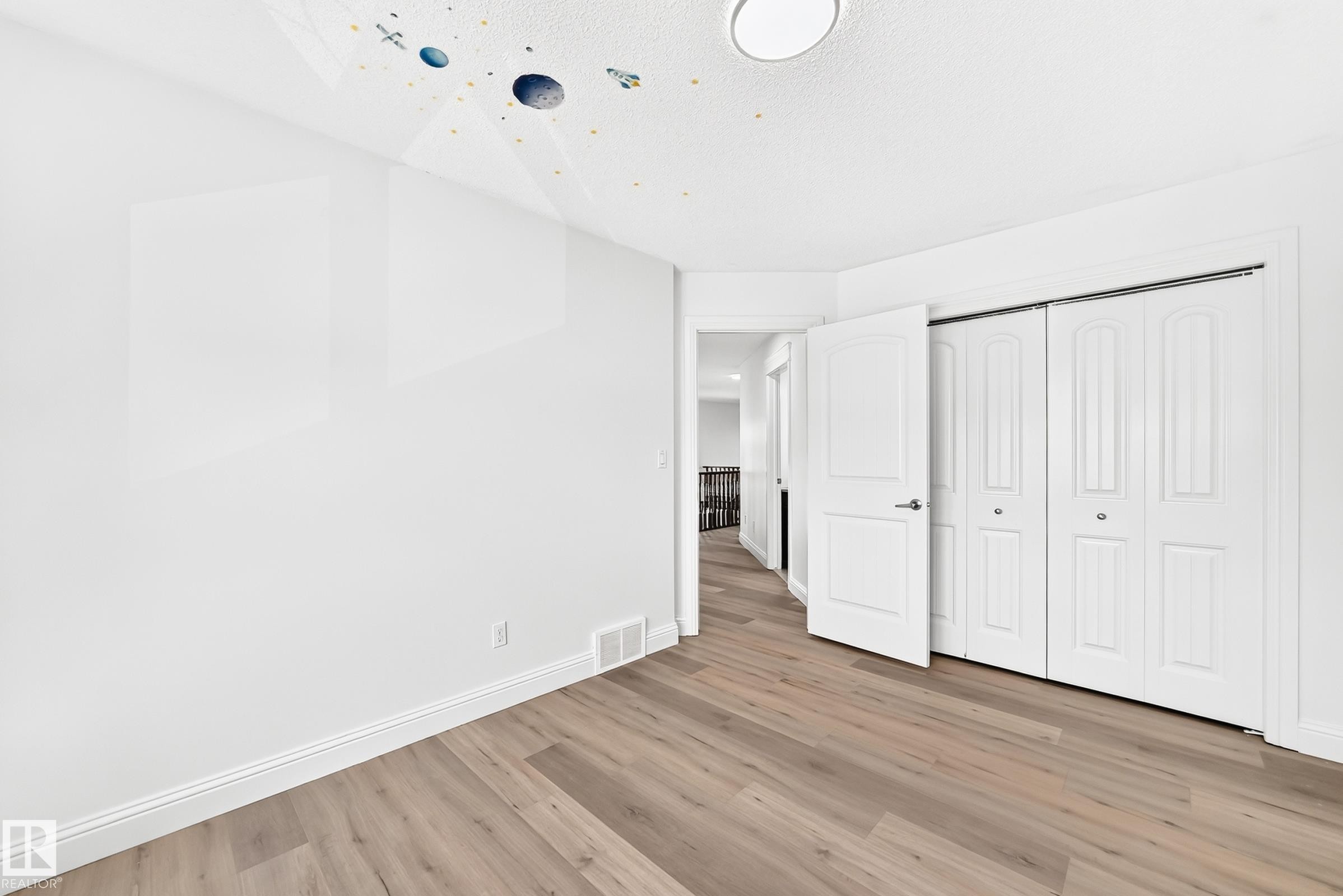 Neutral-toned wood-finish flooring, white walls, and bright white trim - 1663 Rutherford Road Sw, Edmonton, AB - Indoor Photo Showing Other Room