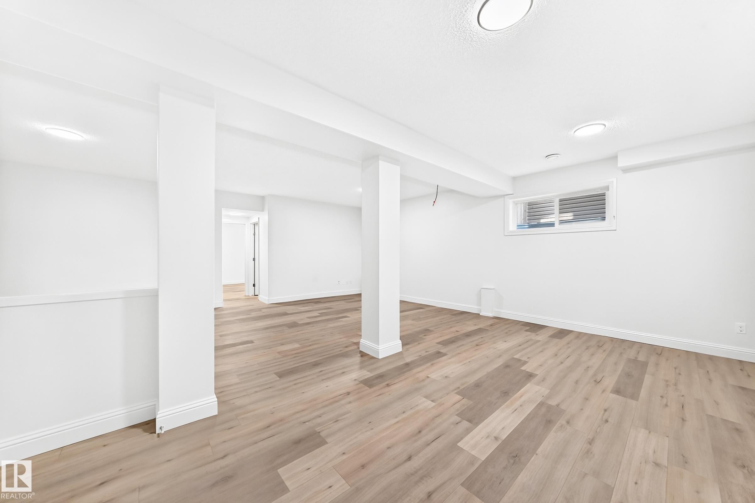 Spacious interior featuring wood-finish flooring, recessed lighting, and a white color palette - 1663 Rutherford Road Sw, Edmonton, AB - Indoor