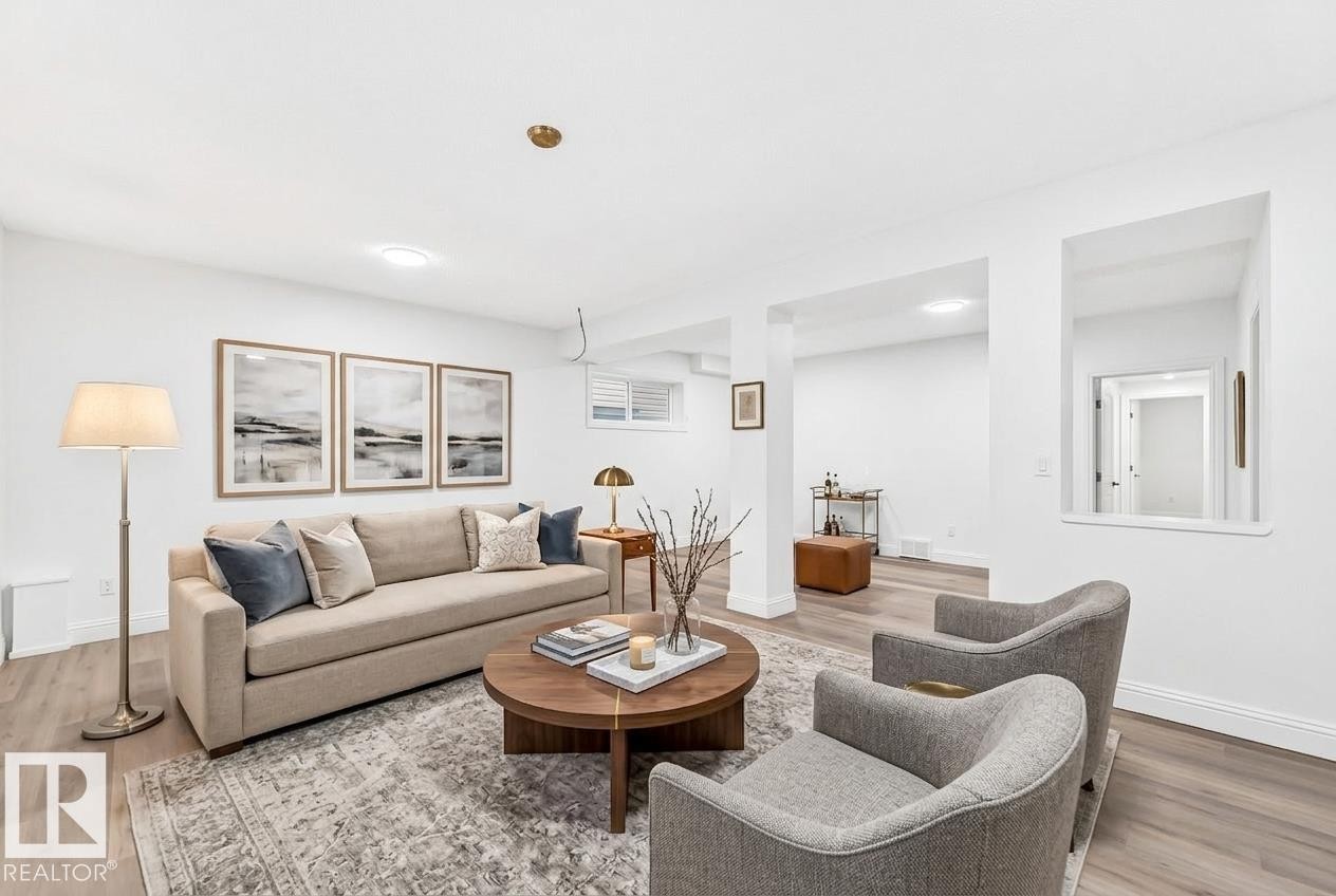 Spacious common area featuring wood-finish flooring, white walls, recessed lighting, and a window opening to an interior hallway - 1663 Rutherford Road Sw, Edmonton, AB - Indoor Photo Showing Living Room
