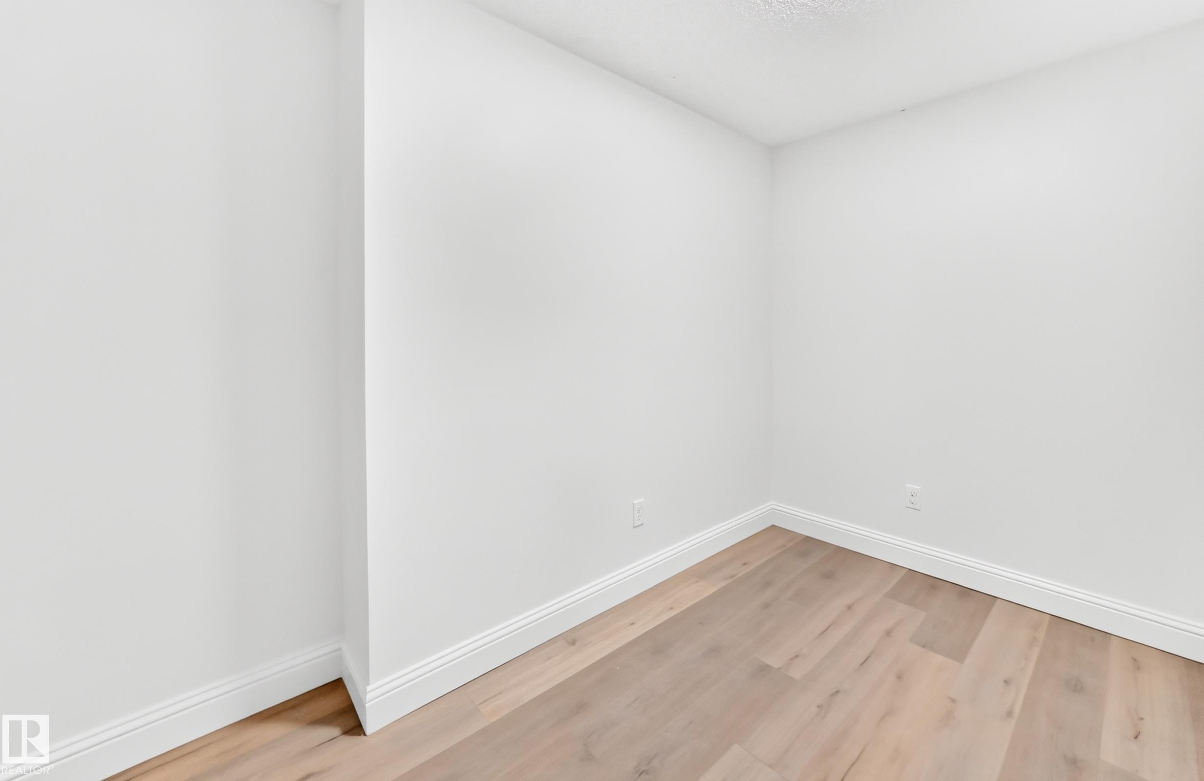 Room featuring light wood-finish flooring, crisp white walls, and bright white baseboards - 1663 Rutherford Road Sw, Edmonton, AB - Indoor Photo Showing Other Room