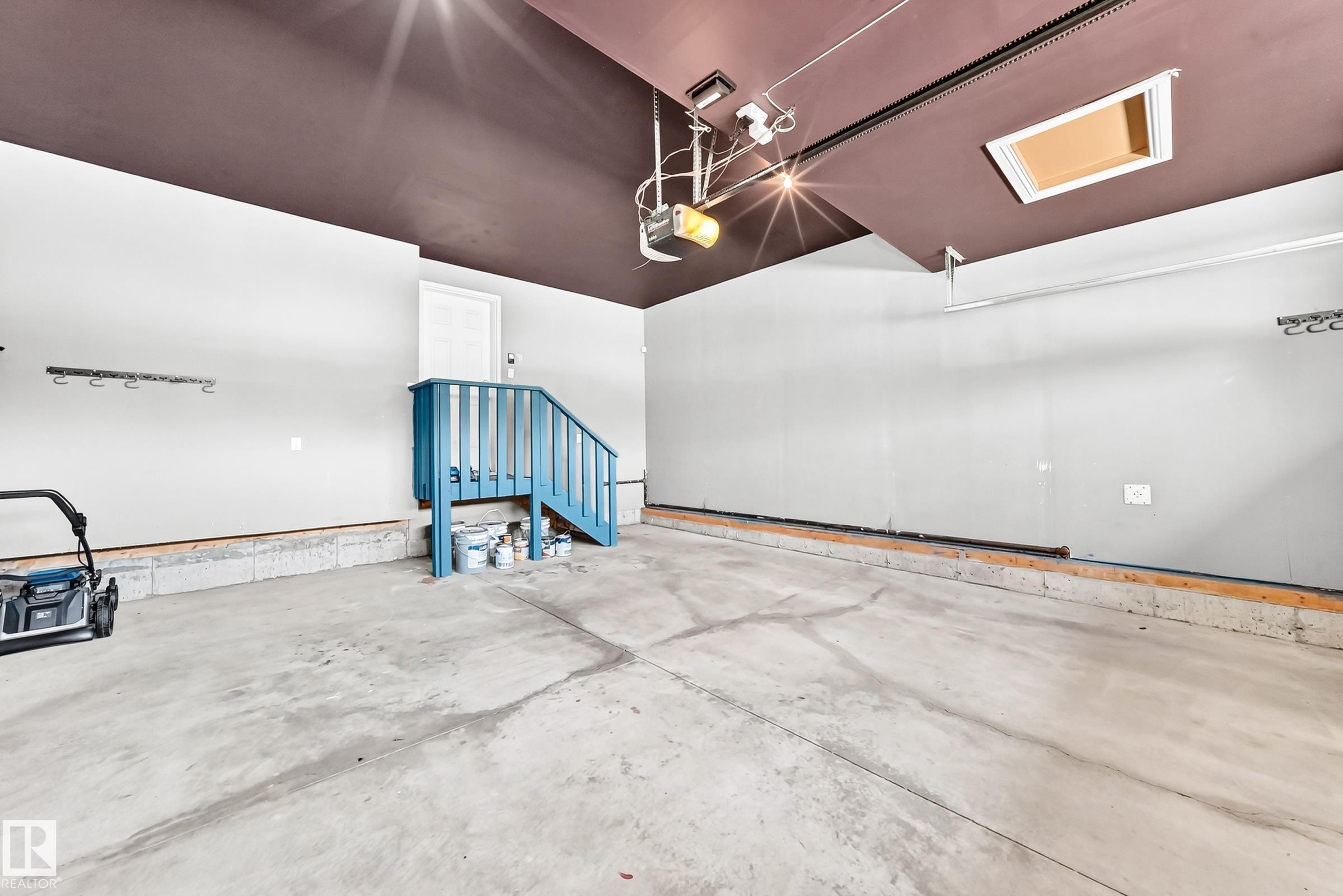 Spacious garage featuring a concrete floor, painted walls, and a finished ceiling - 1663 Rutherford Road Sw, Edmonton, AB - Indoor Photo Showing Garage