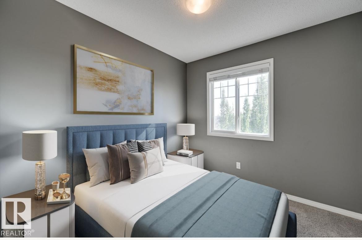 Bedroom featuring a large window, neutral gray walls, textured carpeting, and a flush mount ceiling light fixture - #16 460 Hemingway Rd Nw, Edmonton, AB - Indoor Photo Showing Bedroom