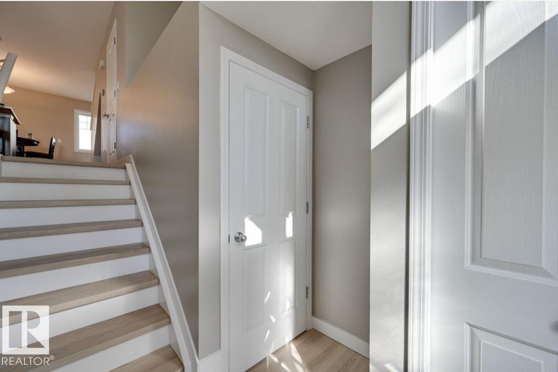 Interior staircase featuring wood-finish treads and white risers - #16 460 Hemingway Rd Nw, Edmonton, AB - Indoor Photo Showing Other Room