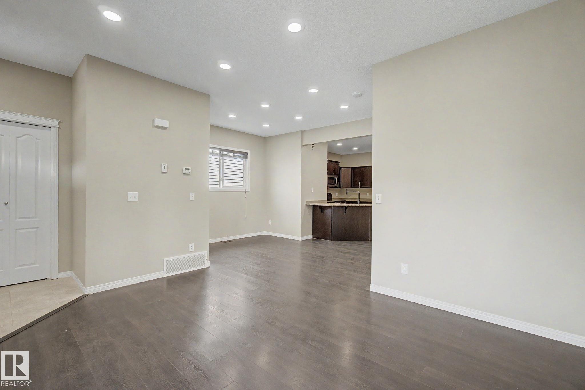 Open-concept living space featuring wood-finish flooring, recessed lighting, and neutral wall tones - 315 Watt Boulevard Sw, Edmonton, AB - Indoor