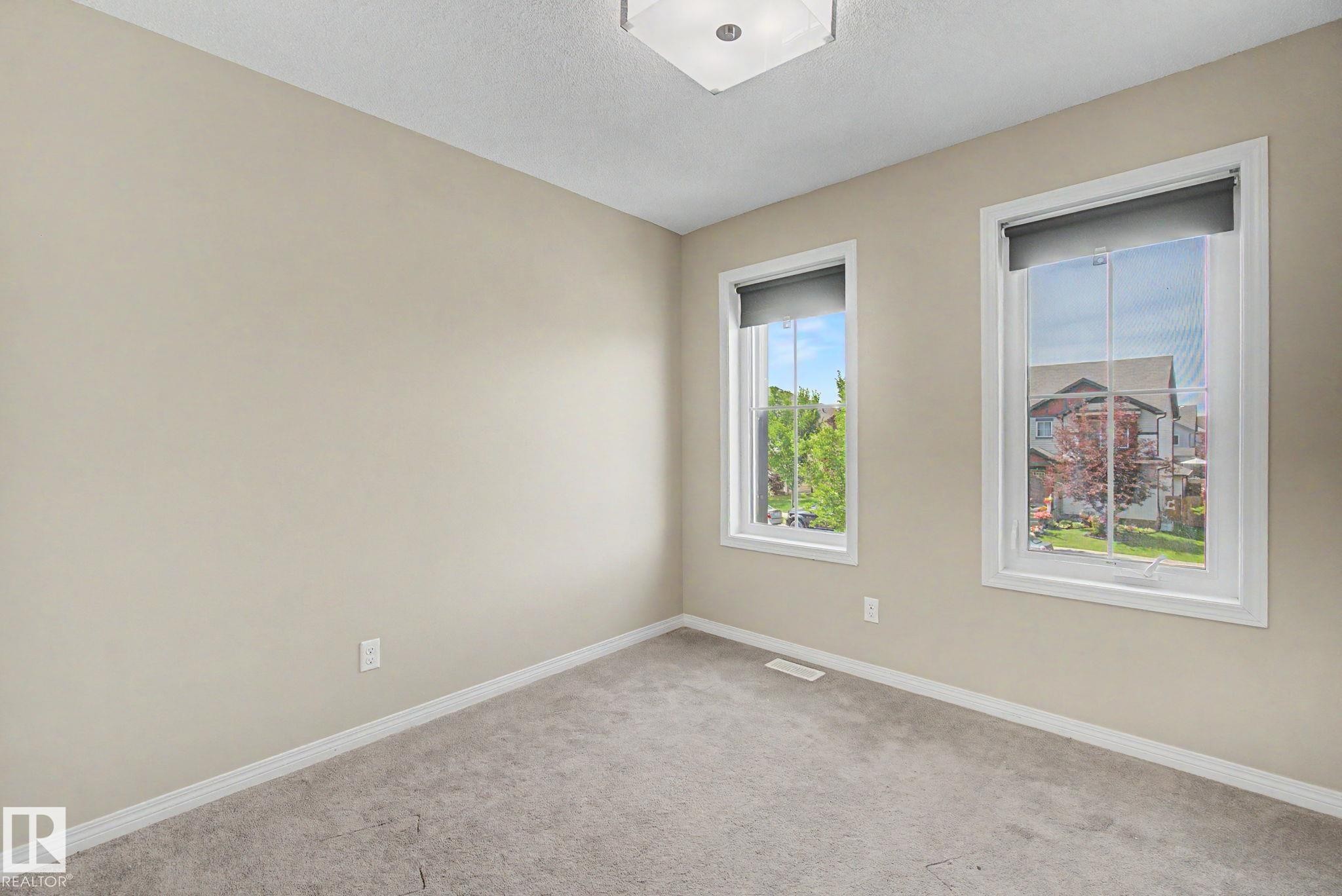Neutral-toned room with plush carpeting and two windows featuring white trim - 315 Watt Boulevard Sw, Edmonton, AB - Indoor Photo Showing Other Room