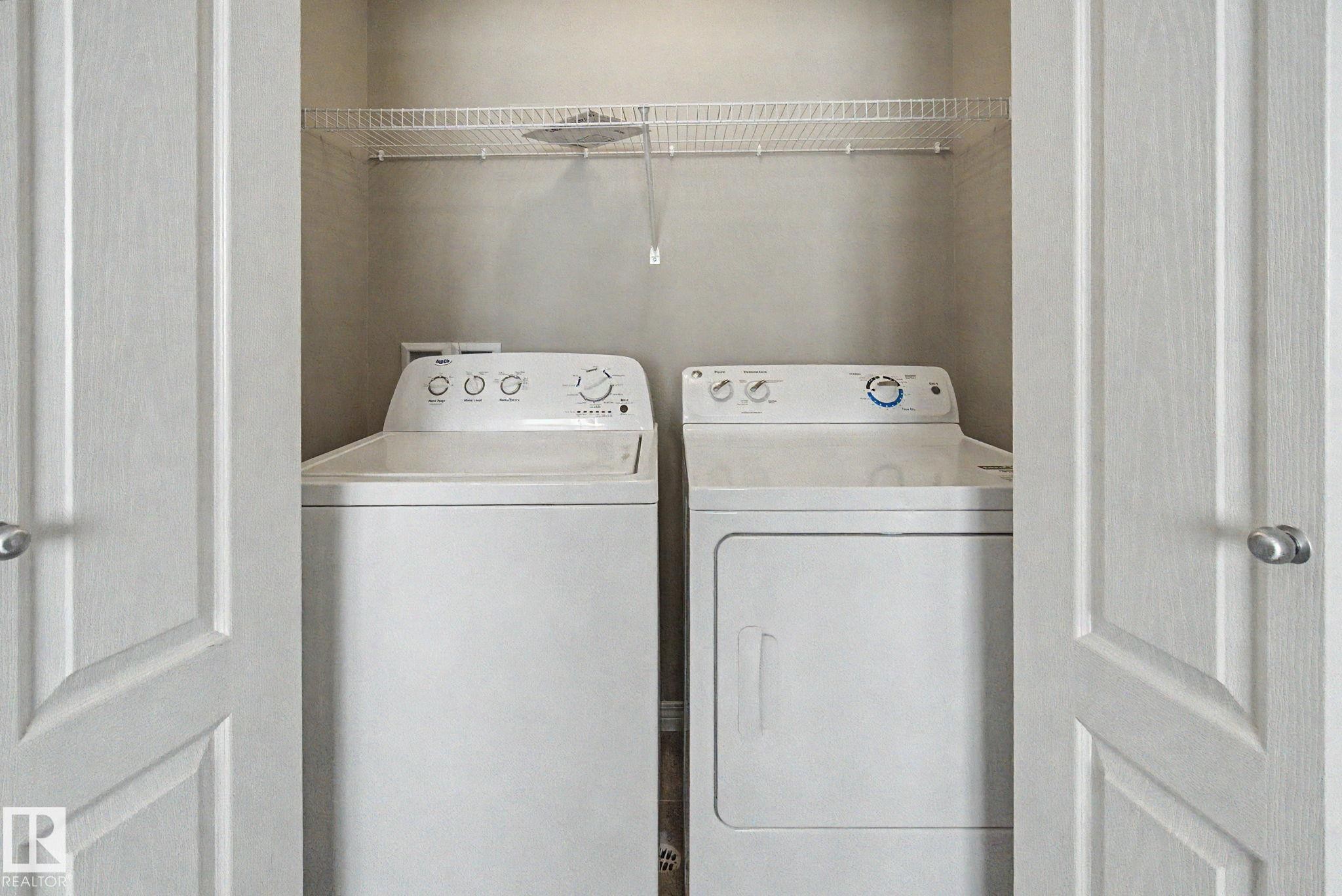 Dedicated laundry closet featuring a top-load washer, front-load dryer, and an overhead wire shelving unit - 315 Watt Boulevard Sw, Edmonton, AB - Indoor Photo Showing Laundry Room