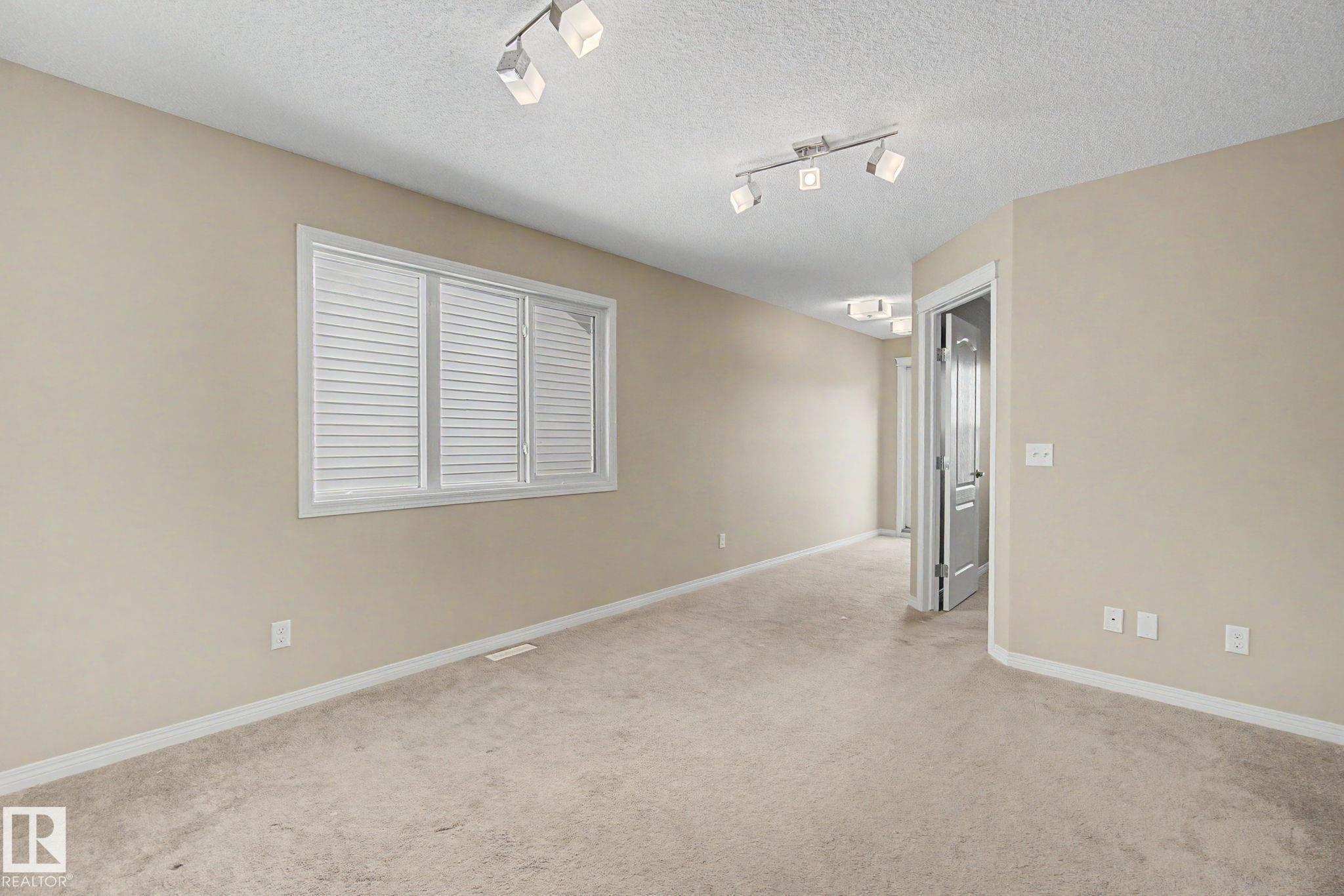Carpeted interior space with neutral wall tones and white baseboards - 315 Watt Boulevard Sw, Edmonton, AB - Indoor Photo Showing Other Room