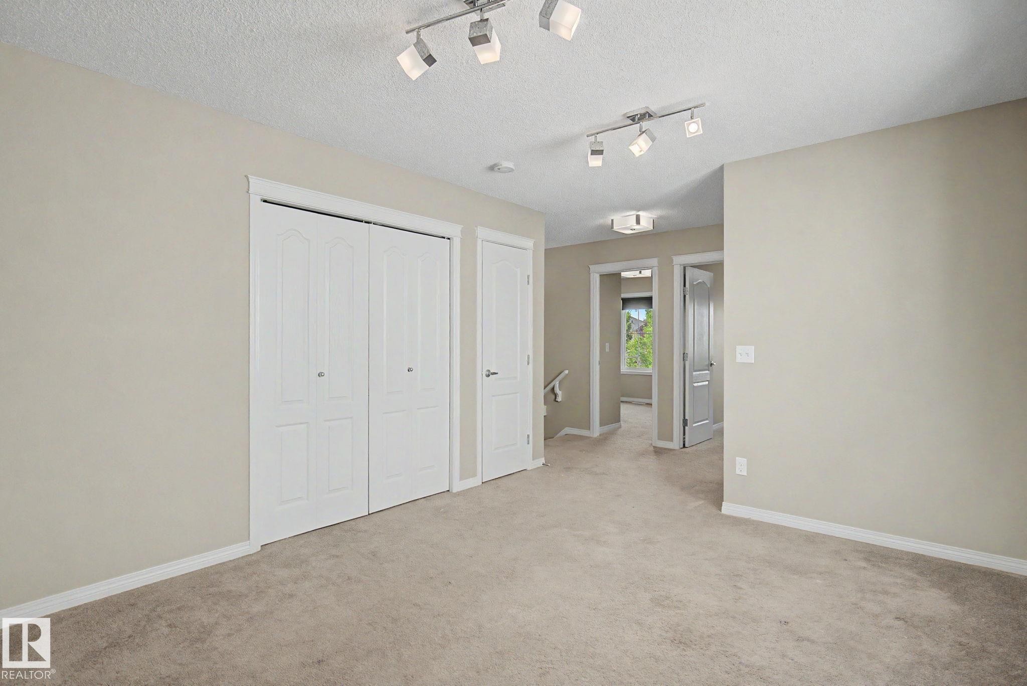 Neutral-toned room featuring track lighting and a double bi-fold closet - 315 Watt Boulevard Sw, Edmonton, AB - Indoor Photo Showing Other Room
