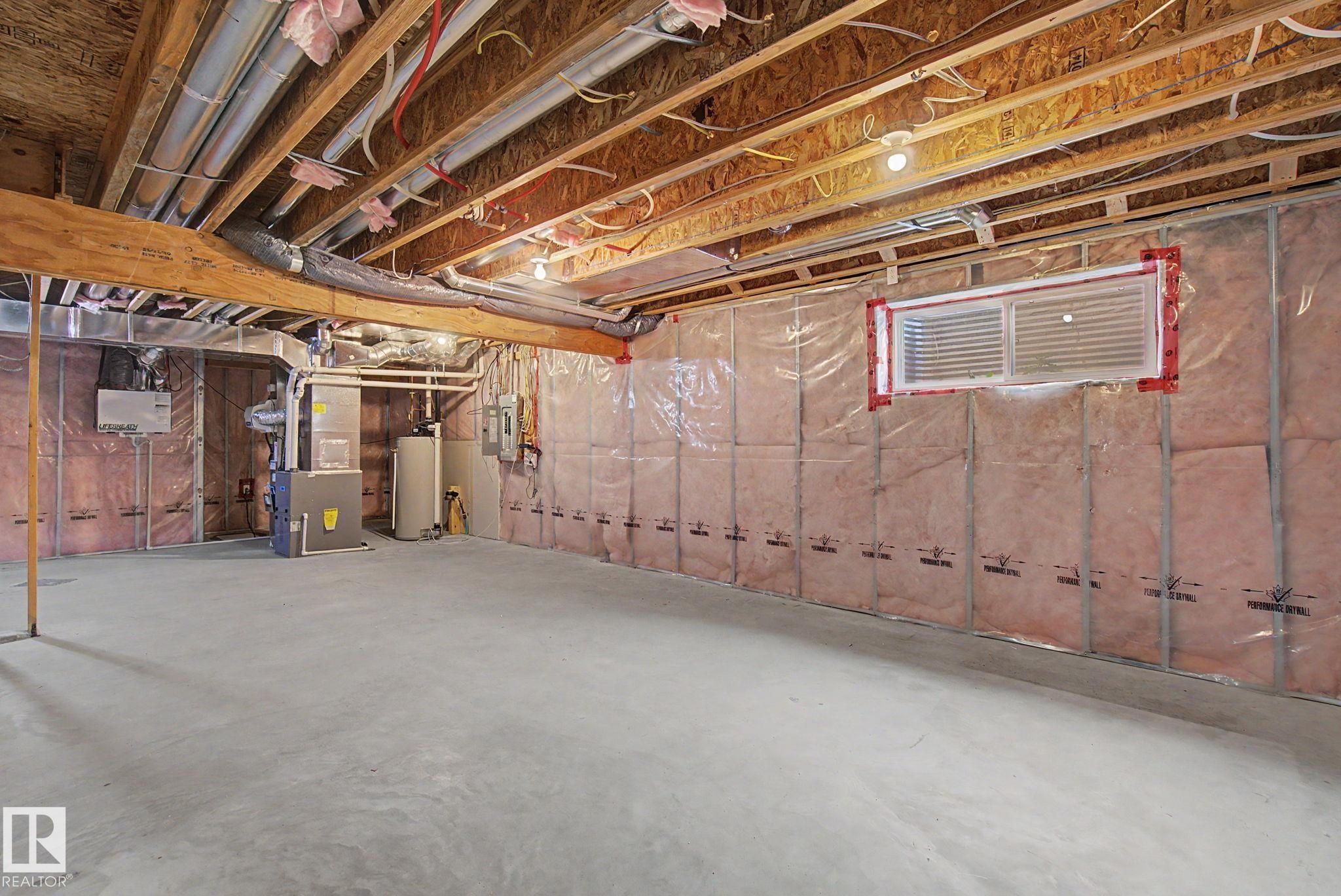 Unfinished basement featuring a concrete floor, insulated walls, exposed ceiling joists, and a horizontal window - 315 Watt Boulevard Sw, Edmonton, AB - Indoor Photo Showing Basement