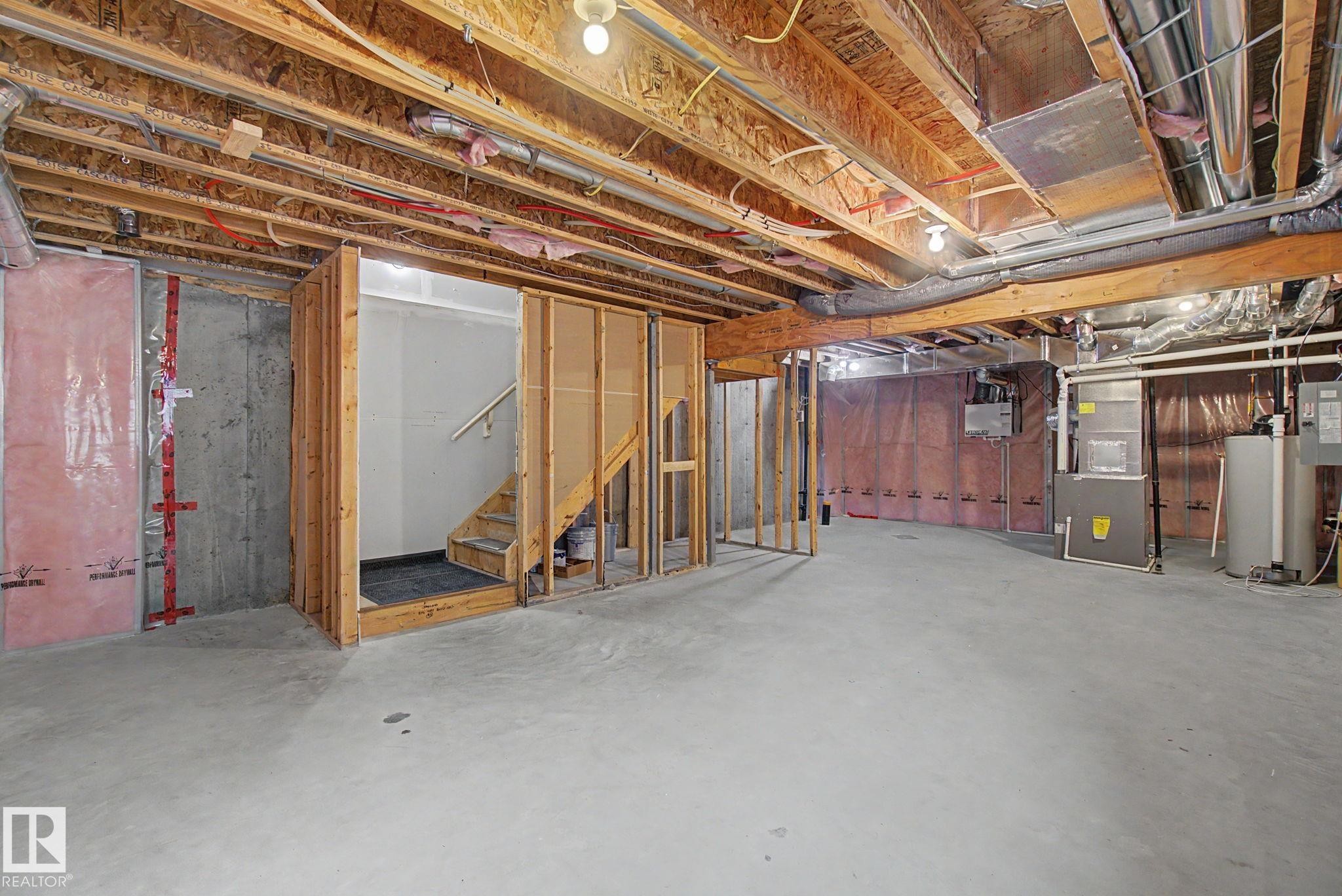 Unfinished lower level offering concrete flooring, exposed ceiling joists, framed stairwell, and visible utility systems - 315 Watt Boulevard Sw, Edmonton, AB - Indoor Photo Showing Basement